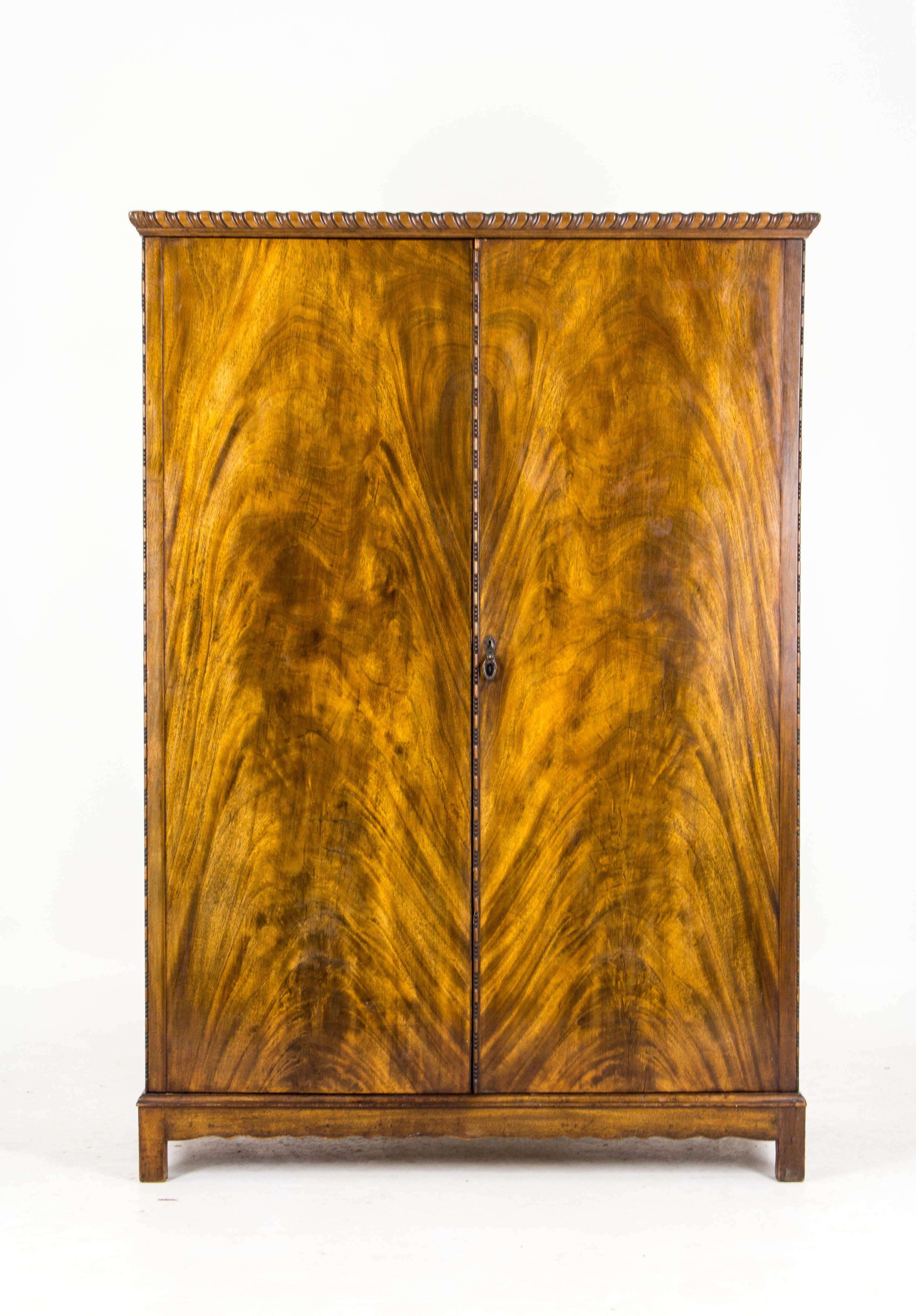 B557 antique Scottish flamed mahogany fitted armoire wardrobe, closet.

Scotland, 1930s
Original finish
Solid mahogany and veneers
Wonderful burr walnut
Two doors enclosed with hanging space, other side with a bank of slide out drawers
Nice