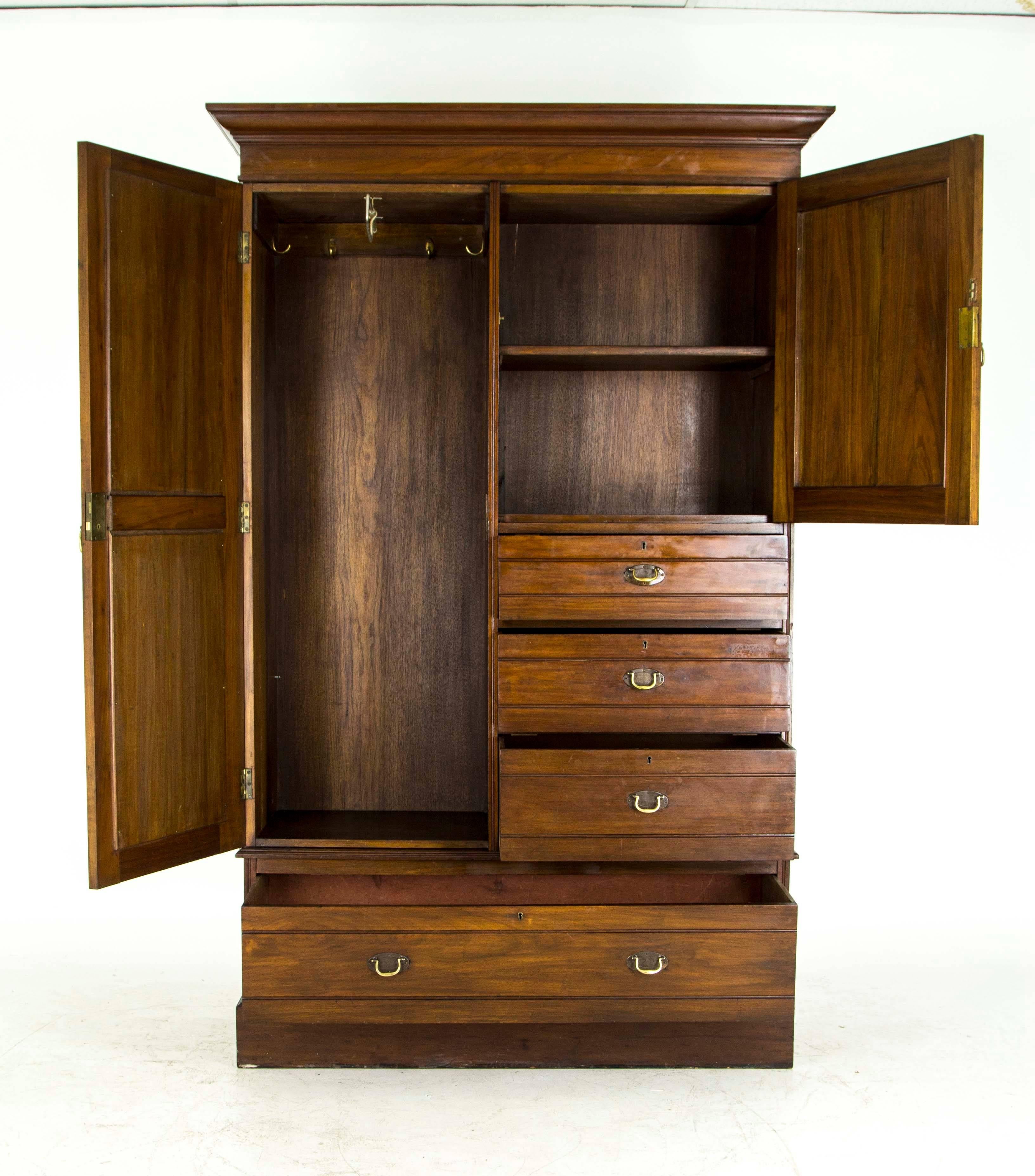 Scotland. 
1880.
Solid mahogany.
Shaped cornice above.
Carved panel door with single shelf.
Three dovetailed drawers to the right.
Full length beveled mirror to the left with hooks and hanging bar.
Full drawer below.
Ending on a Plinth