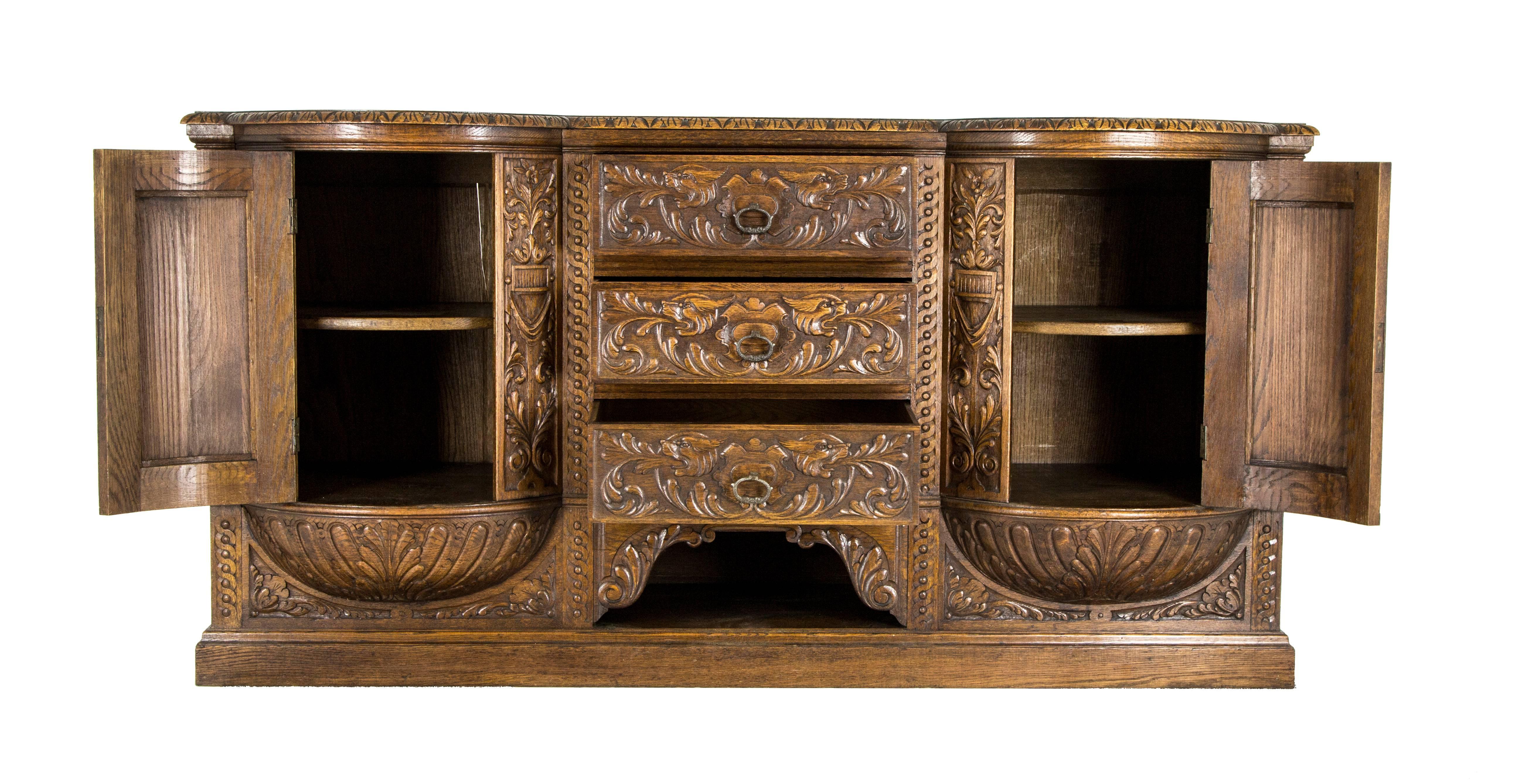 Scotland, 1890
Solid oak construction
Original finish
Shaped top with carved frieze
Three carved dovetailed drawers
Flanked by two bow front doors with single thick shelf interior
Sitting on a carved urn base
Ending on a plinth base
All original,