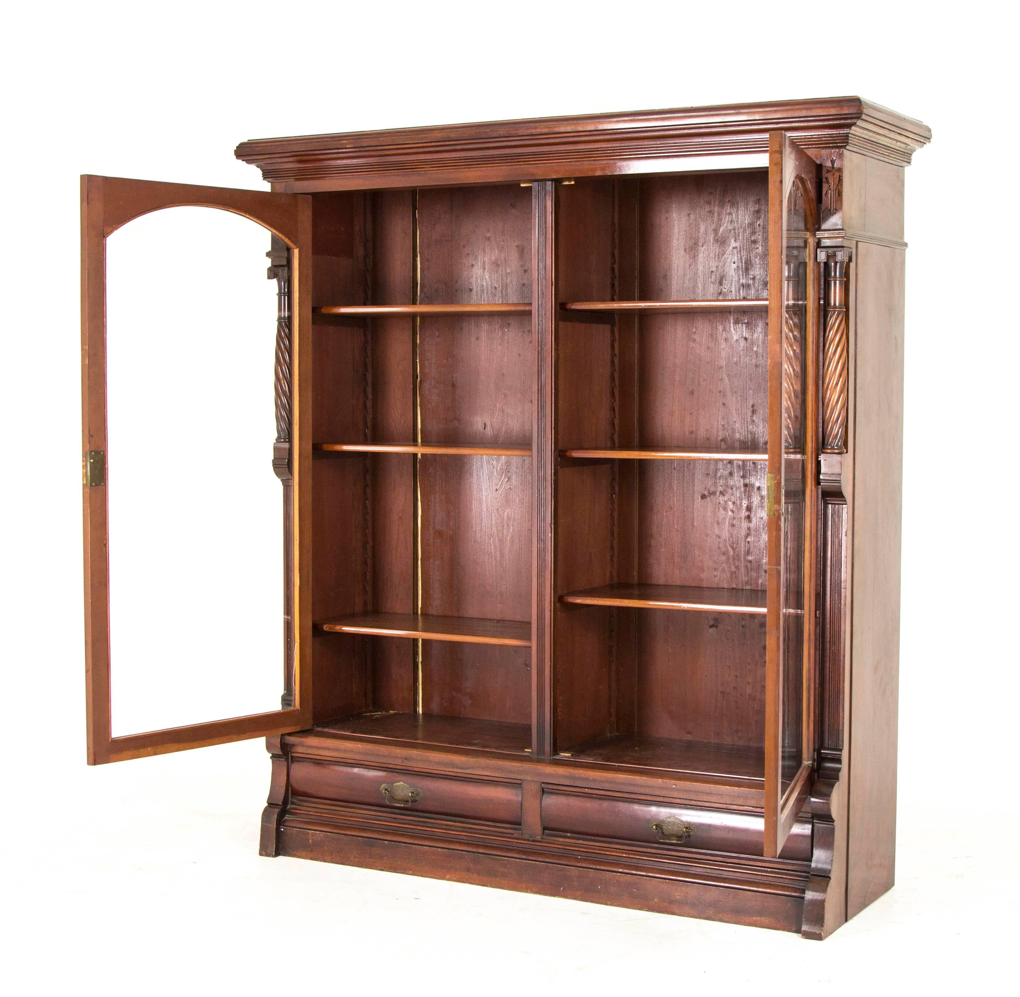 Eastlake bookcase antique display cabinet victorian walnut B813,

American, 1890.
Solid walnut construction
Original old finish
Overhang cornice above
Two original glass doors
Six adjustable interior shelves
Carved column sides
Two dovetailed