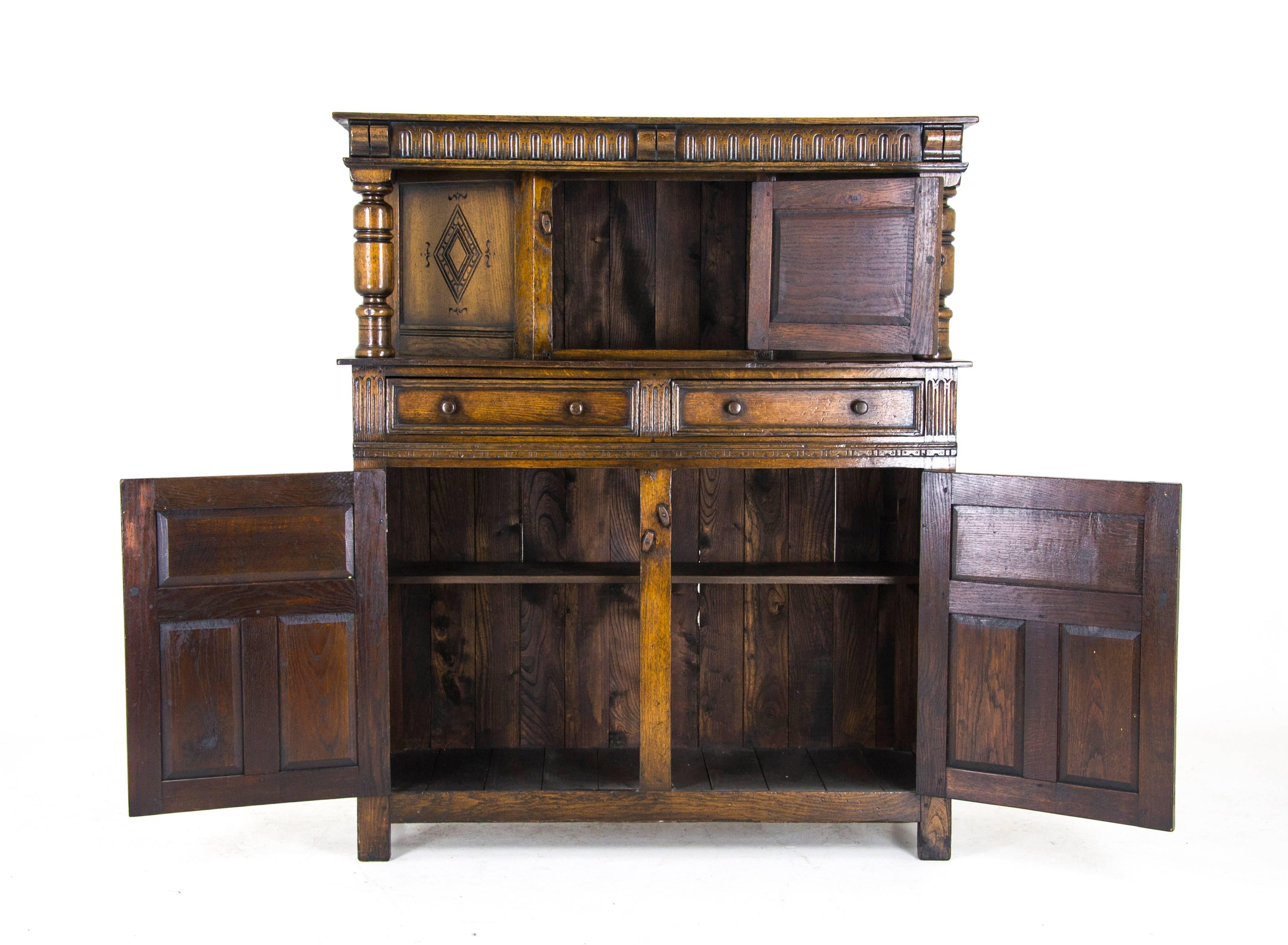 Oak court cupboard carved oak sideboard, Scotland, 1910

Scotland, 1910
Solid oak construction with original finish
Uppers section has three carved panelled sides
Supported by two turned supports
Two dovetailed drawers below
Two carved panelled