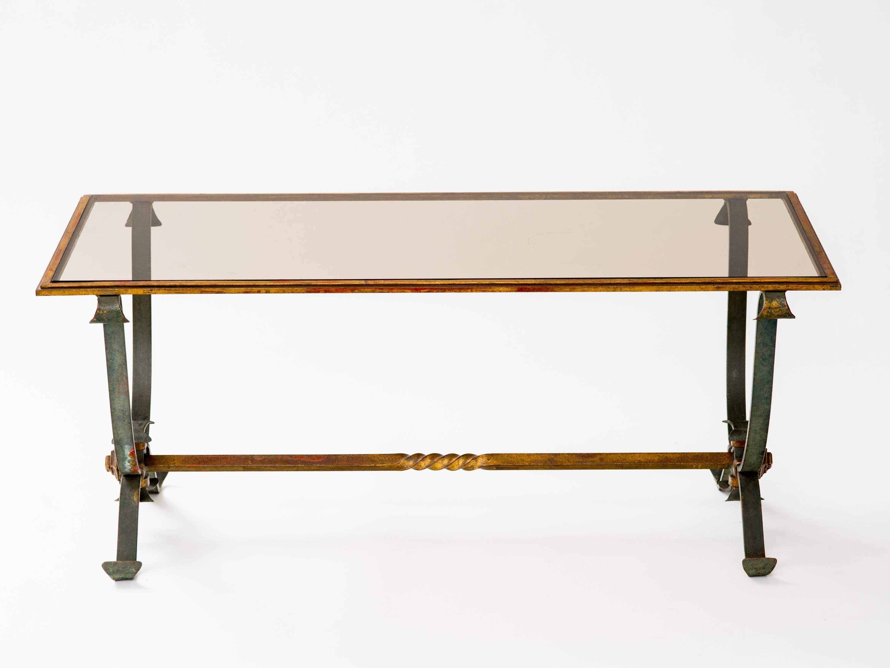 Gracious patinated wrought iron coffee table with gilt detail. Smoke glass top set in patinated bronze frame, France, circa 1940s.