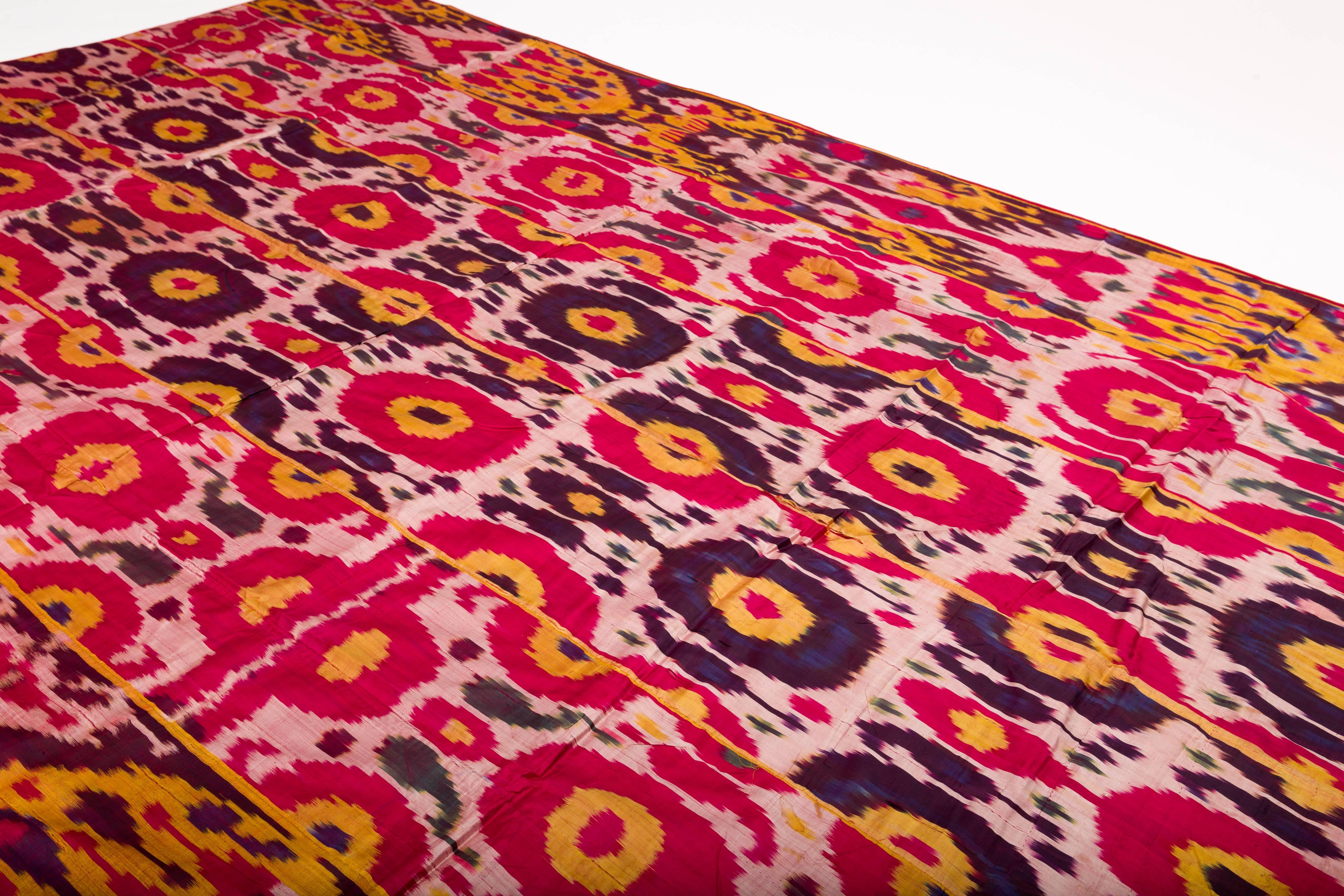 Precioso tejido Ikat de seda tejida a mano en ricos colores magenta, dorado y morado, hacia finales del siglo XIX-principios del XX, Uzbekistán, Asia Central, en la antigua Ruta de la Seda. Soporte original de algodón exótico victoriano magenta