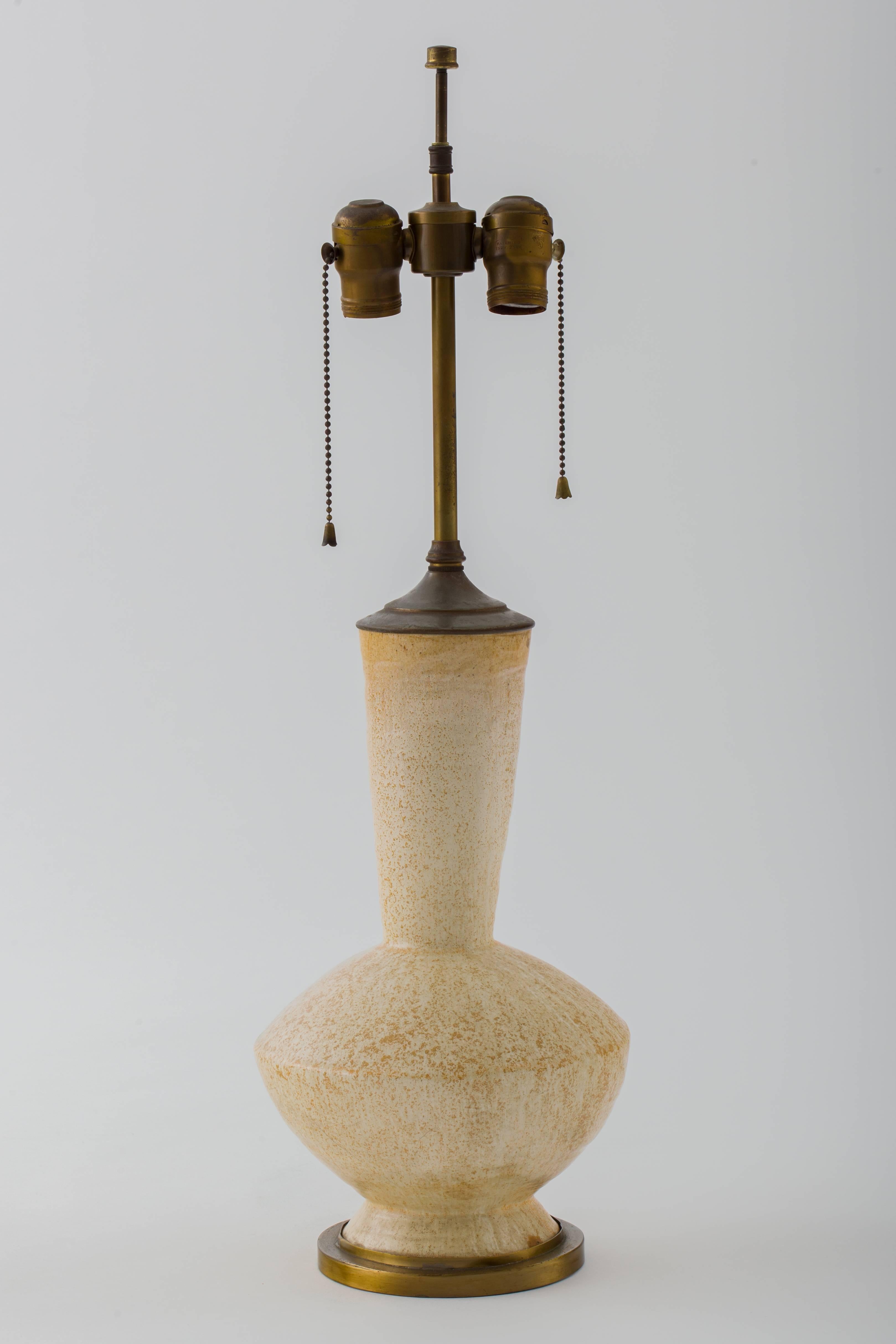 Pair of rare signed Elsie De Wolfe hand thrown ceramic lamps executed by Frances Serber, ceramicist for Elsie de Wolfe inc.  These have unique hues of cream, gold and a splash of smoky blue. Original solid brass hardware, double socketed. Lamp body