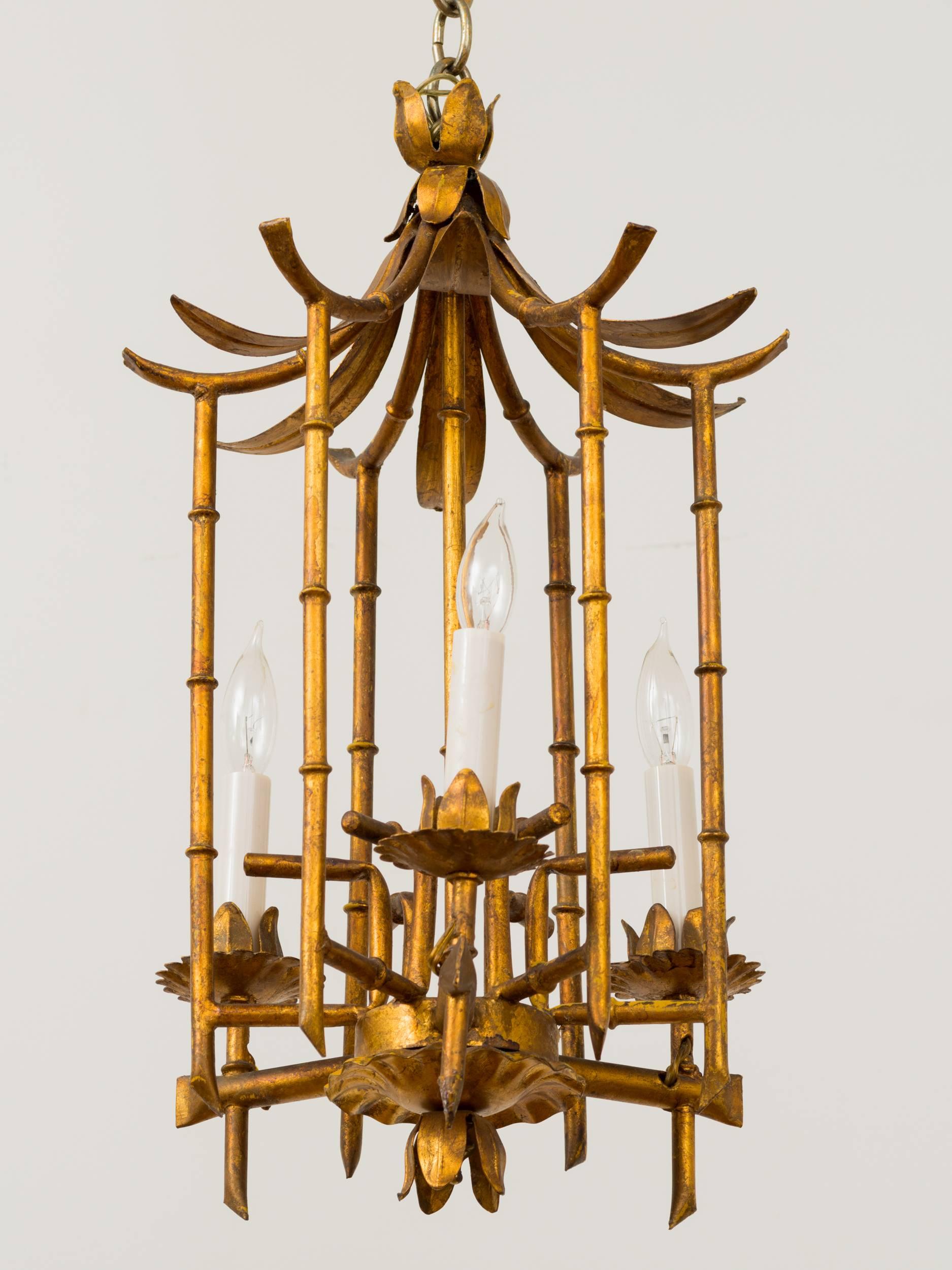 Italian faux bamboo pagoda shape chandelier has distressed faux gilt painted finish. Gilt sunburst shape ceiling cap is original. Height of fixture is adjustable by adding or removing link chain. 

  