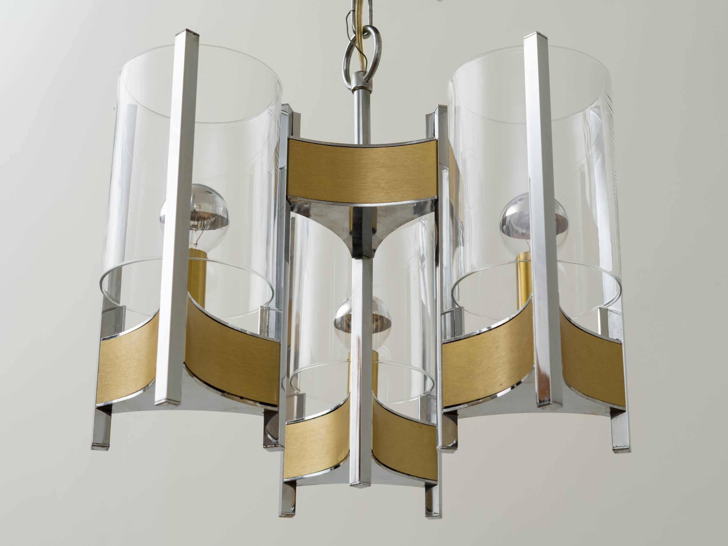 Gaetano Sciolari brushed brass and chrome chandelier with glass hurricane shades, illuminated with partial mercury glass light bulbs. Circular chrome ceiling cap. Height can be adjusted with additional chain links, Italy, circa 1970s.