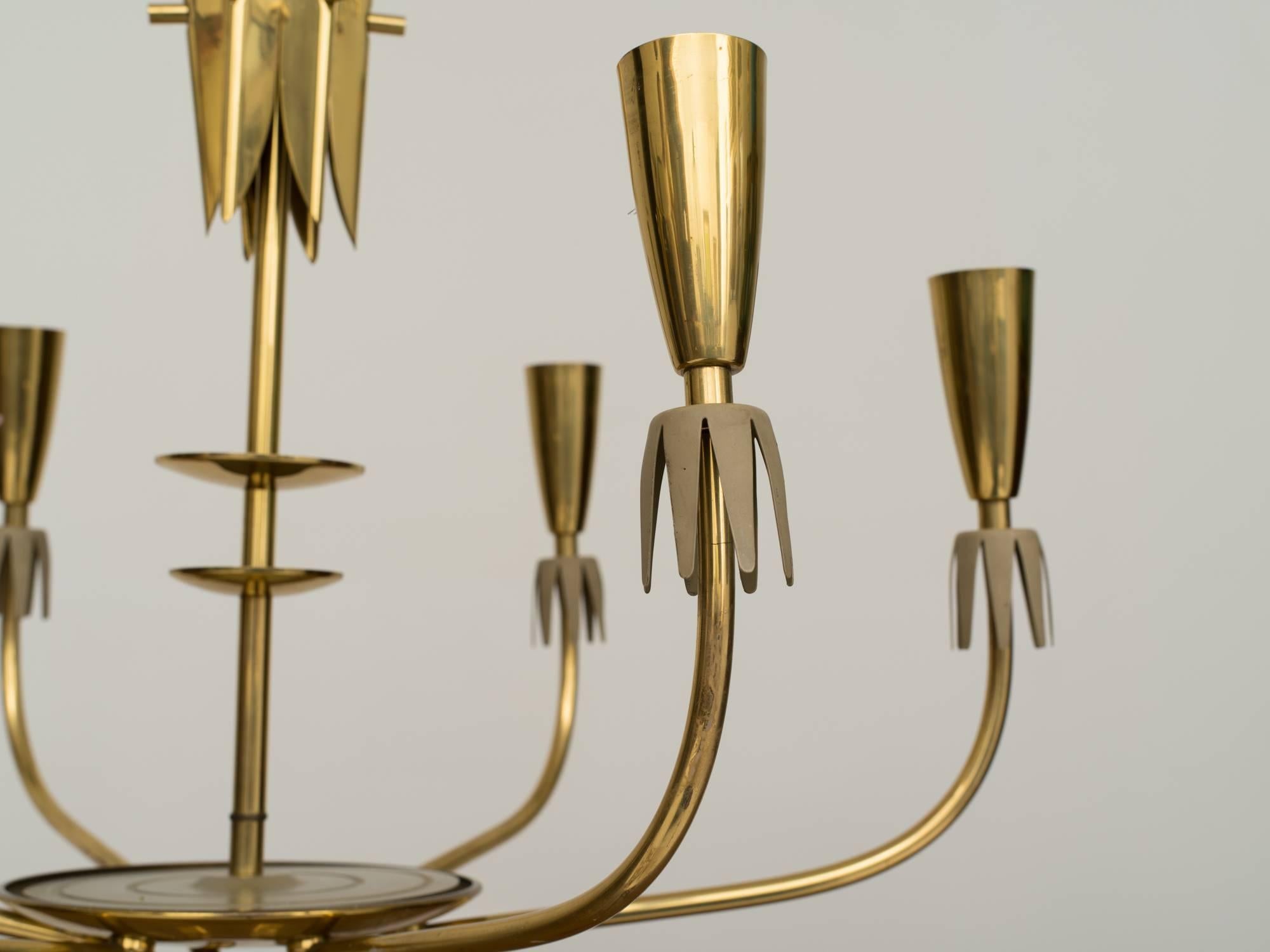 Modernist 1960s German brass six-arm chandelier has brass petals on each cone, making them into flowers when illuminated. Brass rod has central circles and petals attached, with brass ceiling cap.