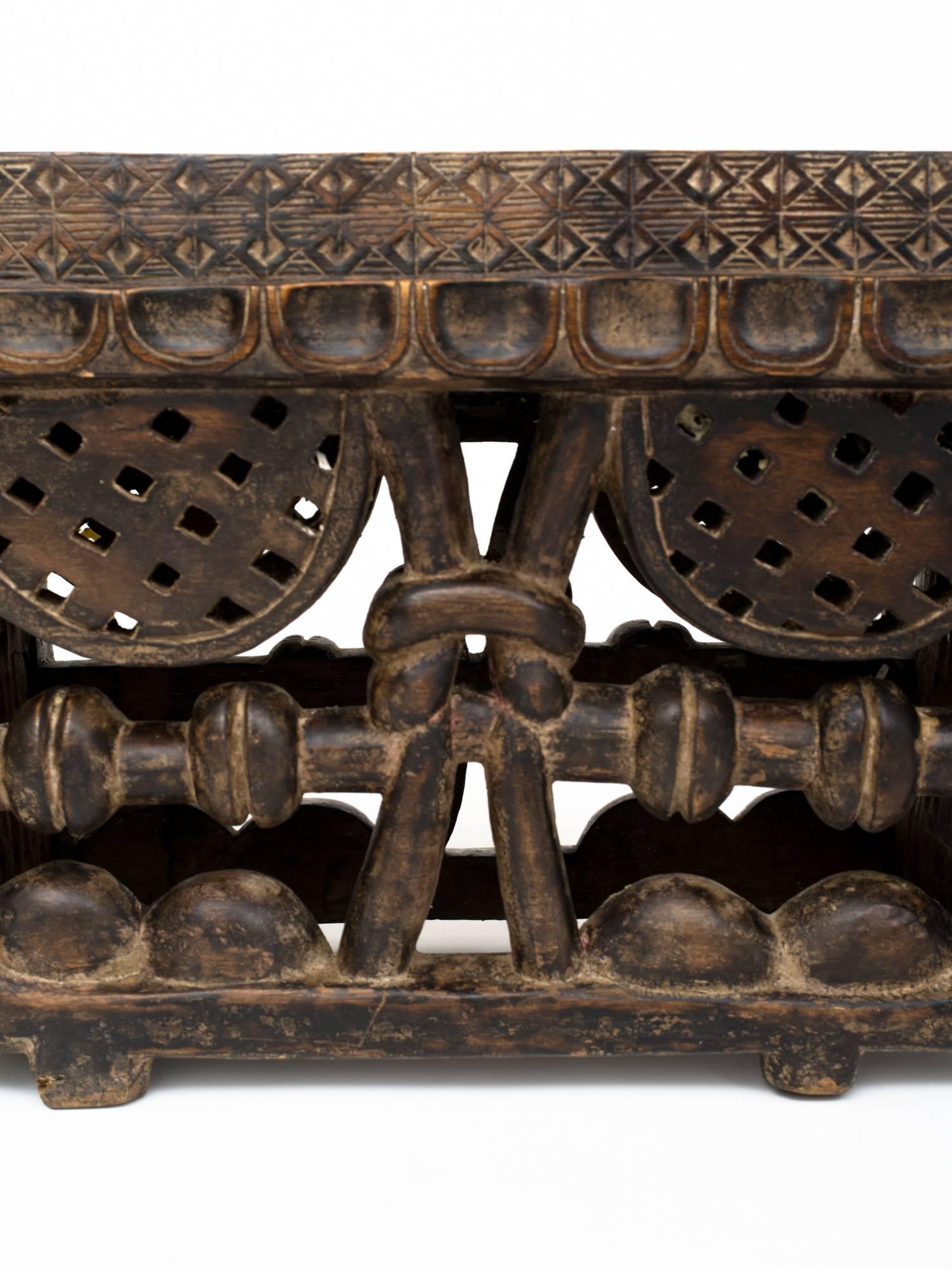 Large West African mahogany hand-carved standing game board. It is sculpted with a knot in the center of two sides, and elaborate carving throughout. 
The game is said to be called Oware, one of the oldest recorded games in the world. It is a West