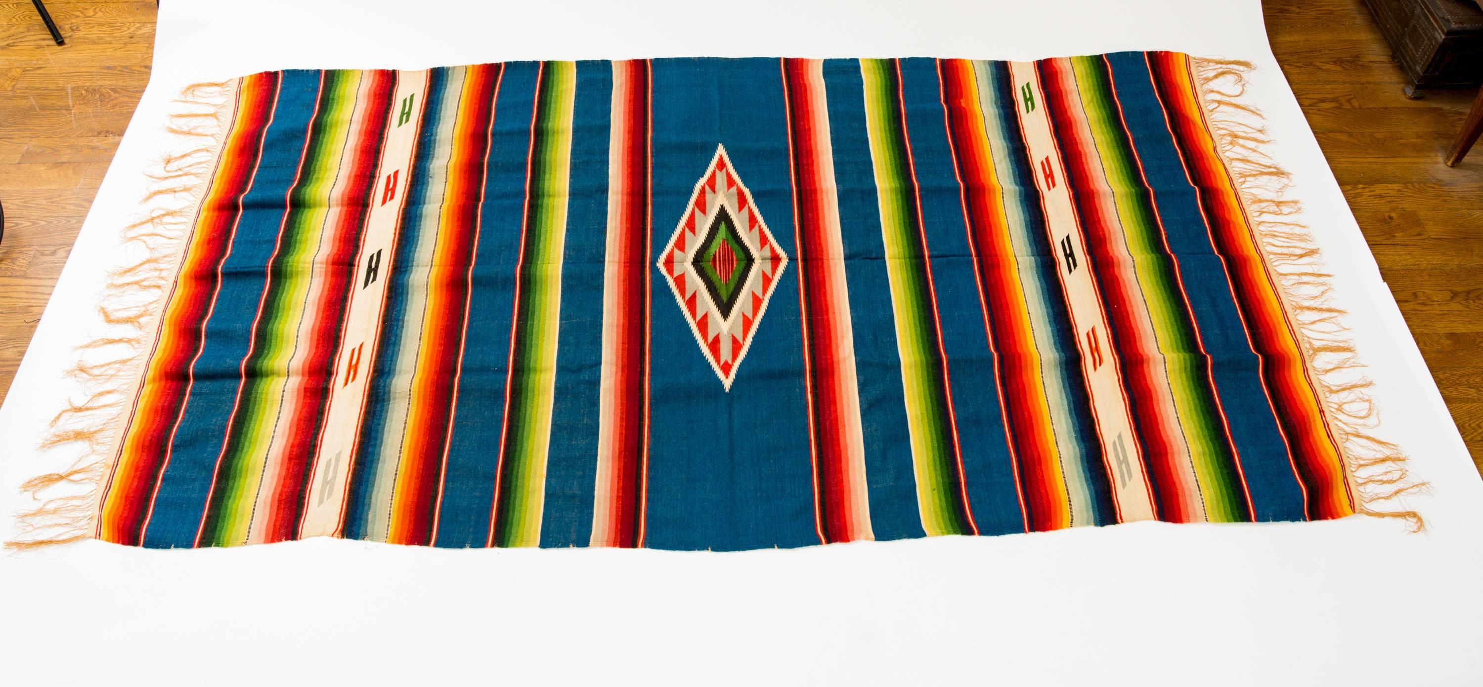 Finely handwoven multi-color stripe Saltillo serape with large central diamond woven on turquoise background, Mexico, circa 1940s.