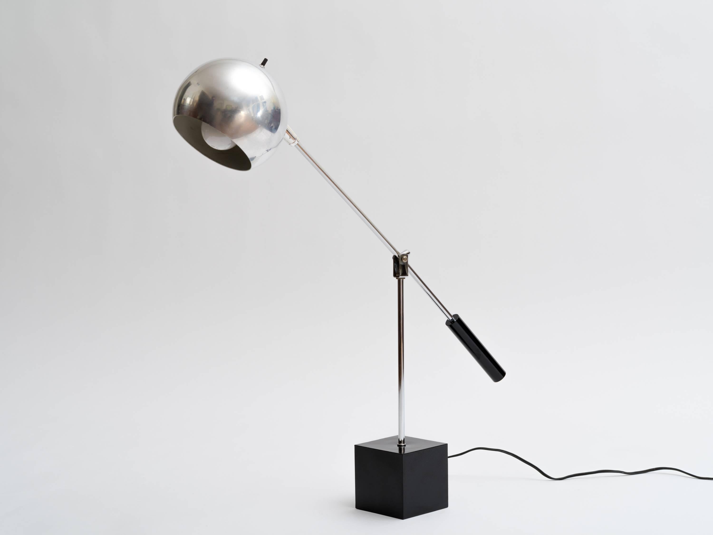 Adjustable 1970s chrome ball desk lamp on enameled metal cube base. Adjusts by height and enameled handle arm swivels giving many degrees of directional lighting.