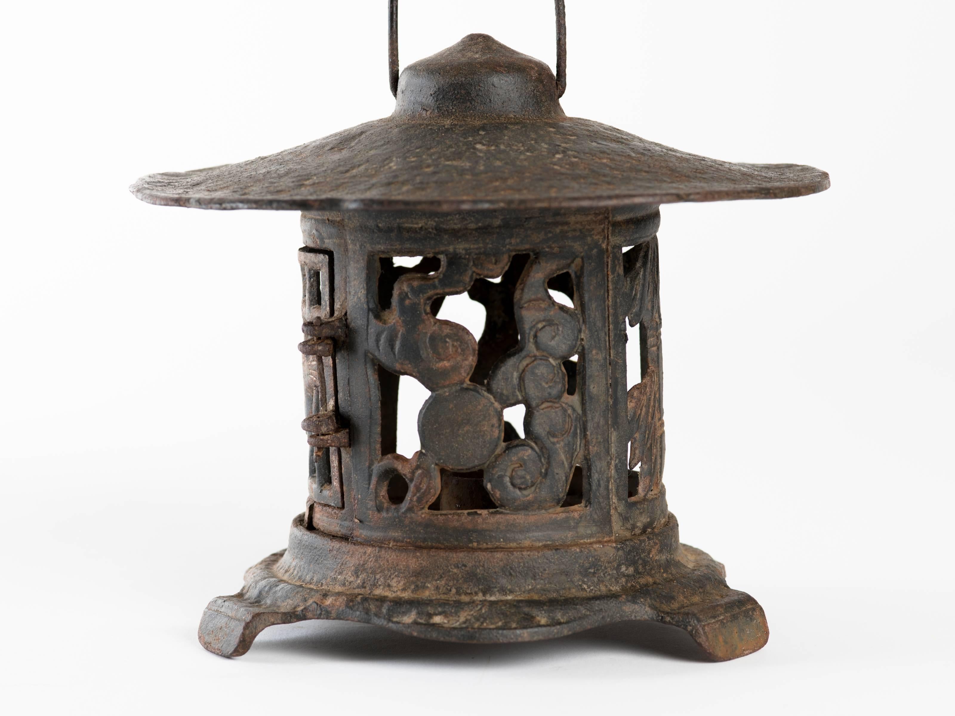 Japanese cast iron pagoda lantern has circular screen sides with tree and bird motif, hinged door. Single candle holder interior. 