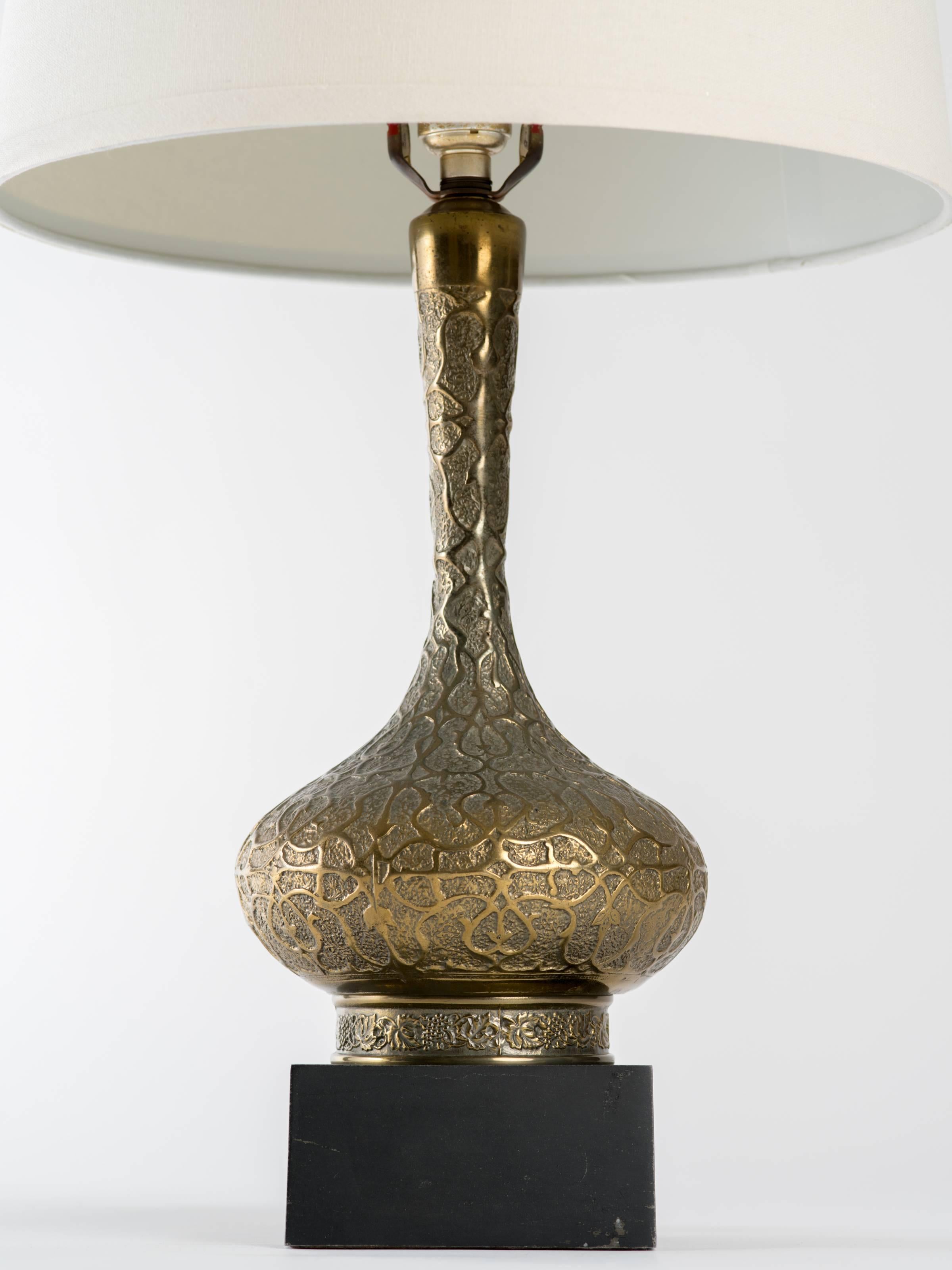 Elegant Moorish style brass lamp on black patinated metal base. Measures 26.5 inches overall height, lamp body 16 inches height. Base measures 5 inches square. Original brass papyrus form finial. Lampshade not included.