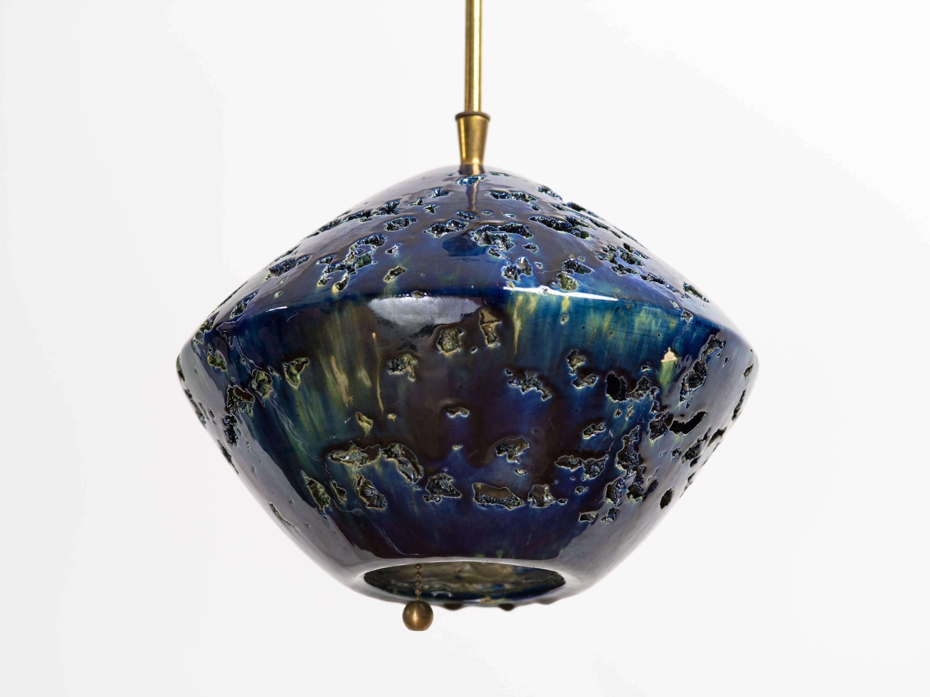 Italian 1960s Brutalist cut-out and glazed indigo ceramic sphere chandelier, with pull chain. Original brass rod and ceiling cap.