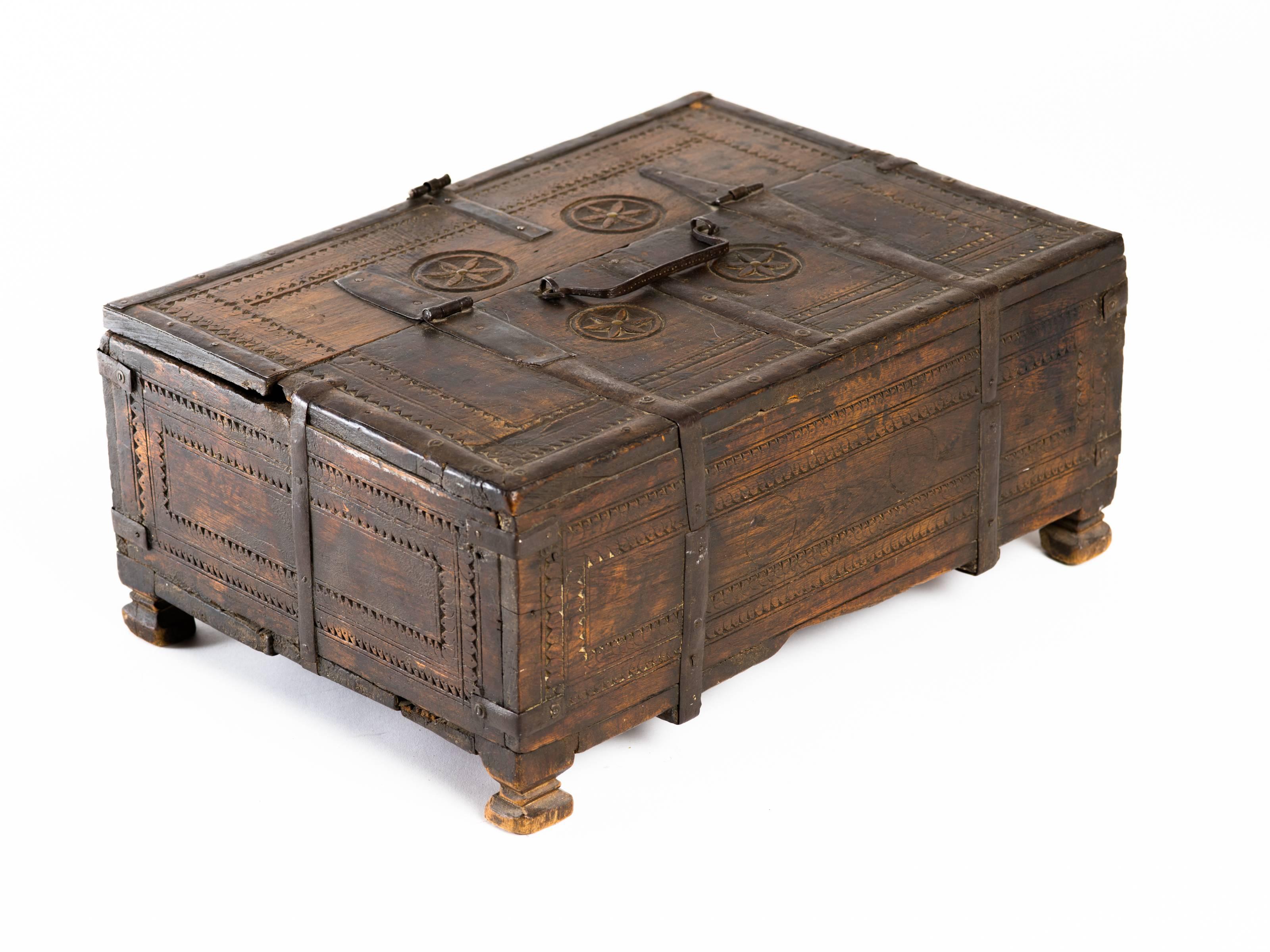 Hand-carved wooden Indian tribal storage chest box with hand-wrought iron hinges and straps, and handle. Early 20th century, Northern India.