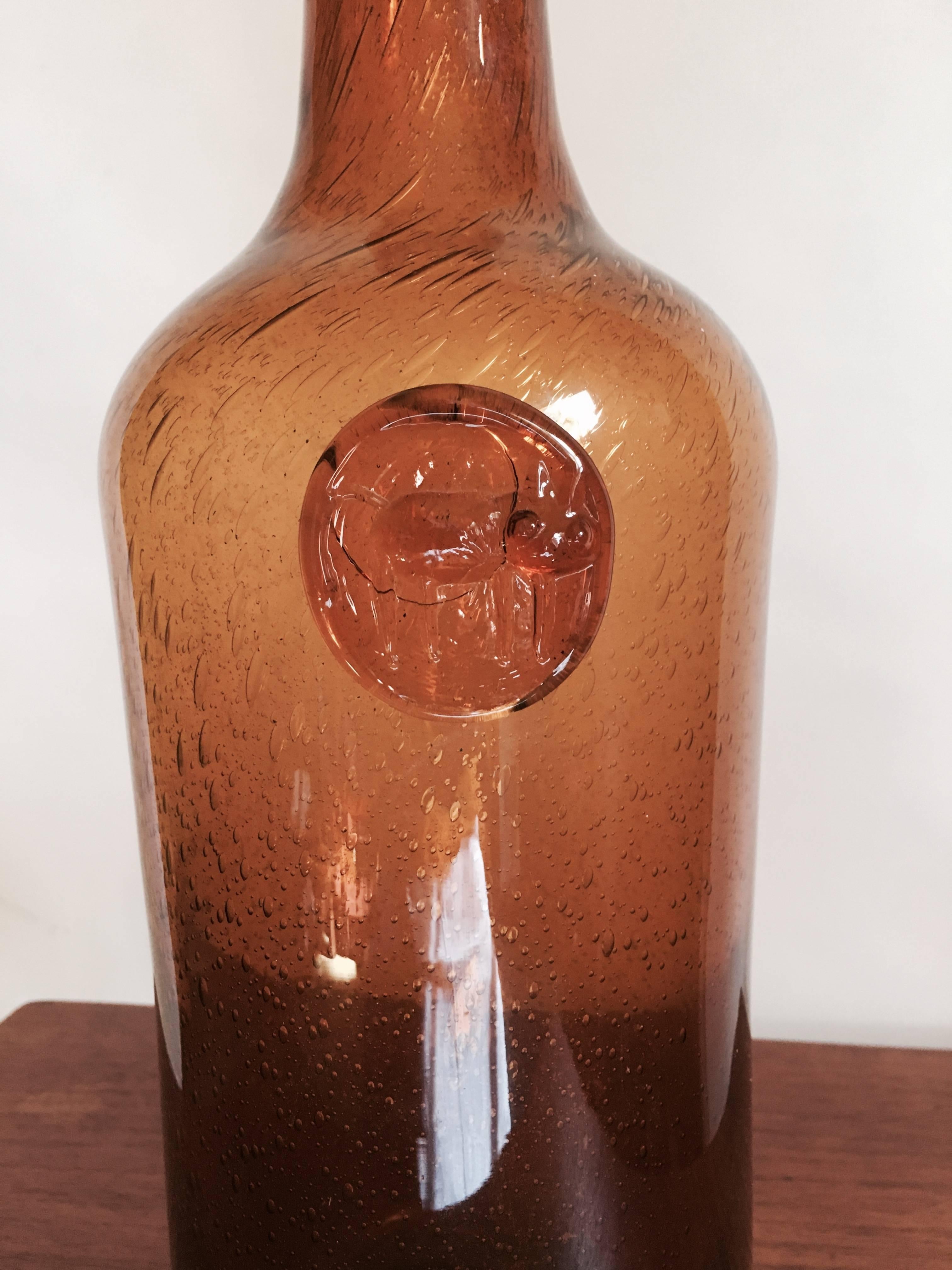 Erik Hoglund amber glass bottle with cat print. Signature bubbles in glass. Handblown vessel with stamped prunt, Swedish, circa 1960. Hand-etched mark on base. Exceptional scale.