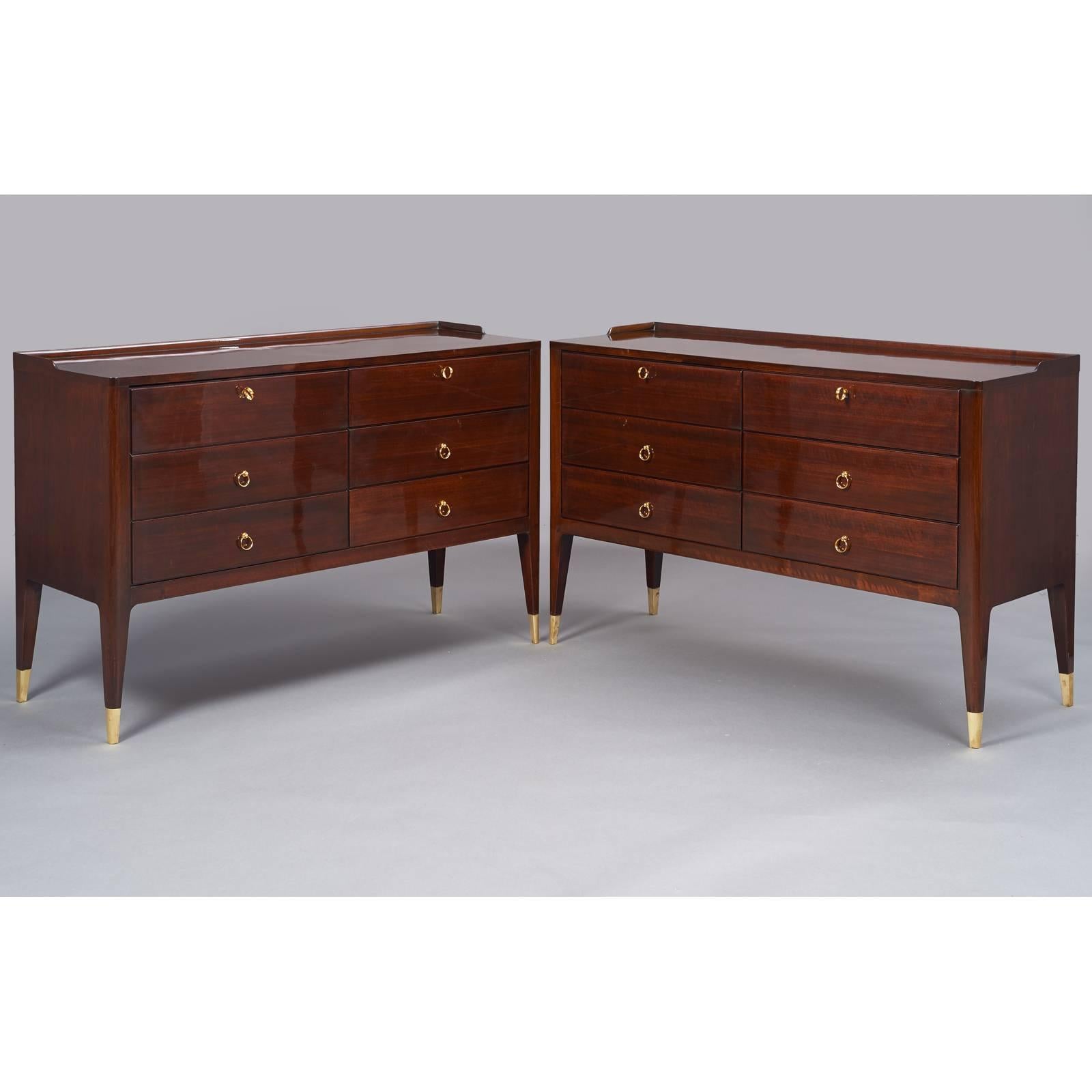 Paolo Buffa, in the style of,

an elegant pair of six drawered cabinets 
in mahogany-stained wood with rounded corners and tapered angled legs.
Brass fittings. Two top drawers with keys, lower four with matching pull,
Italy, 1950s.

Measures:
