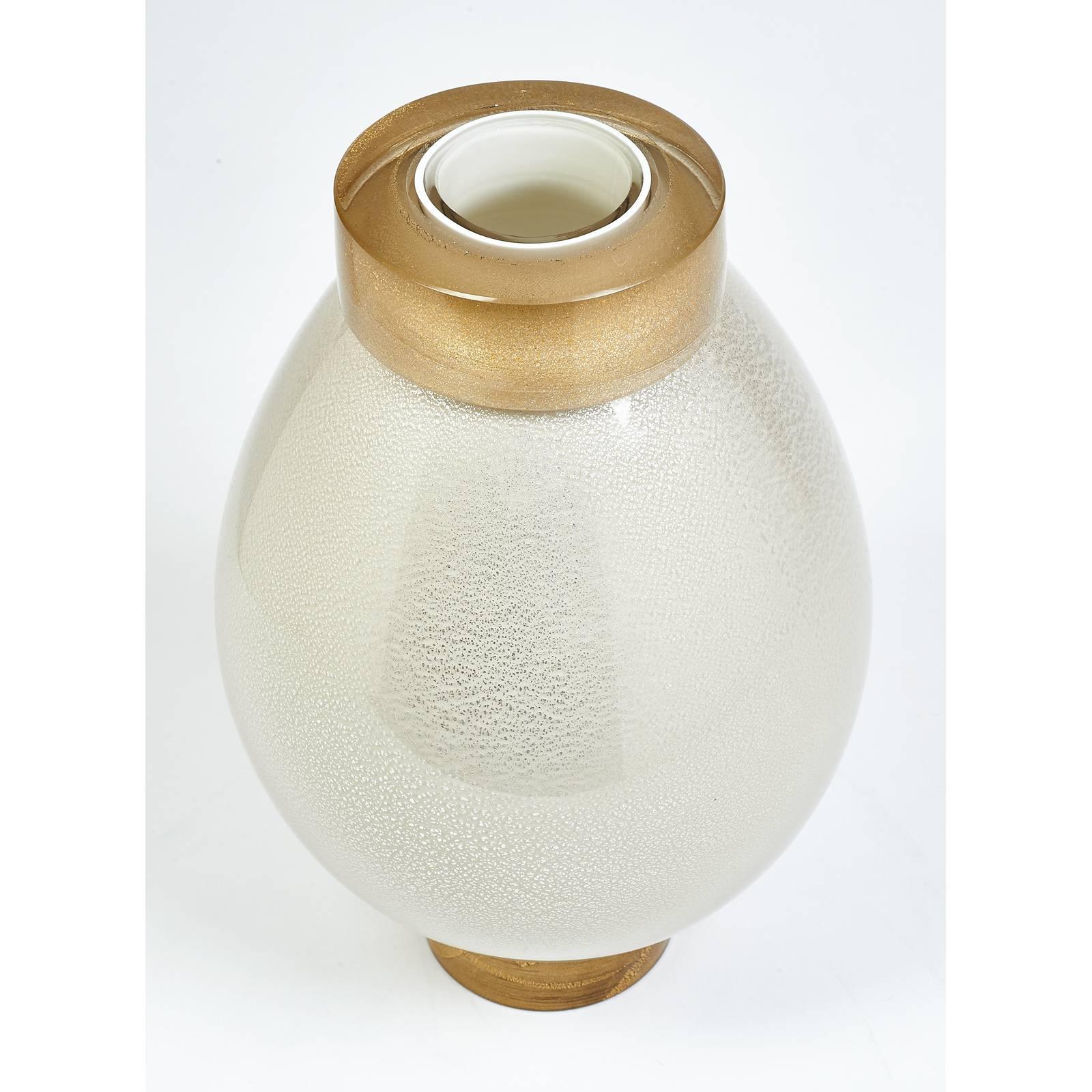 Italy, contemporary
An exquisite blown glass vase, in the manner of Seguso
Multiple layers of clear and opaline glass flecked
with gold leaf (collar and base) and silver leaf (body)
One available.
Measures: 12 height x 7 diameter.