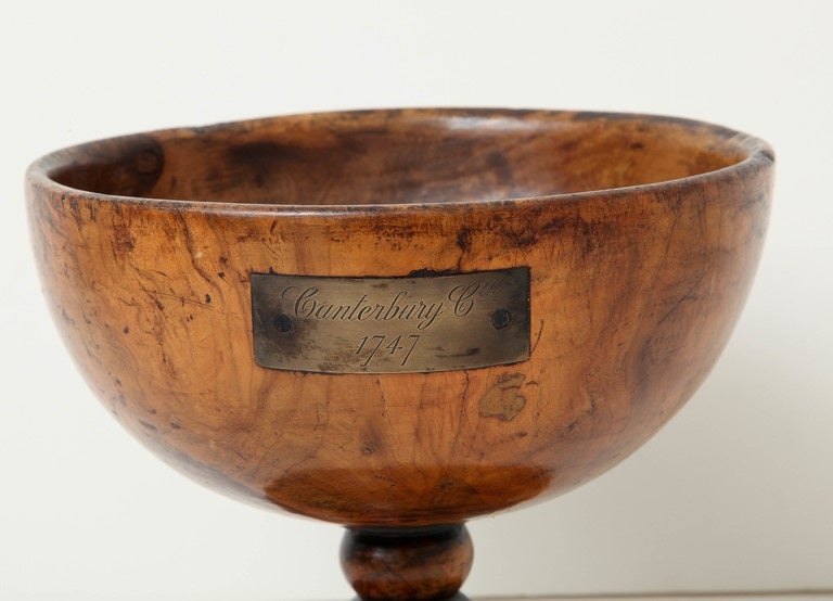 An 18th century English turned olive wood wassail bowl
with brass placque inscribed Cantebury Cth 1747
