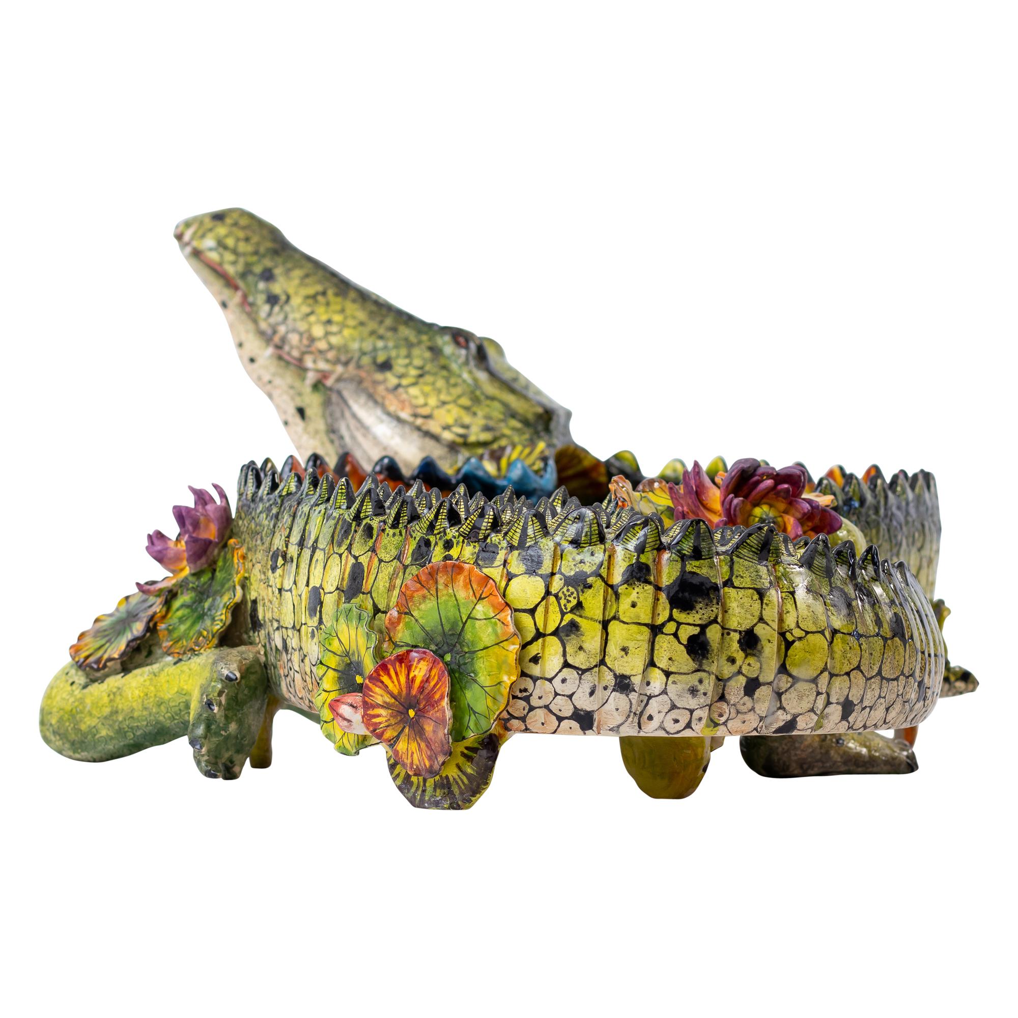 Ciotola Crocodile River Guardian di Wiseman Ndlovu

Questa ciotola Crocodile River Guardian, unica nel suo genere, è un sorprendente capolavoro scolpito e dipinto da Wiseman Ndlovu, uno dei più visionari narratori di ceramica del Sudafrica. Il