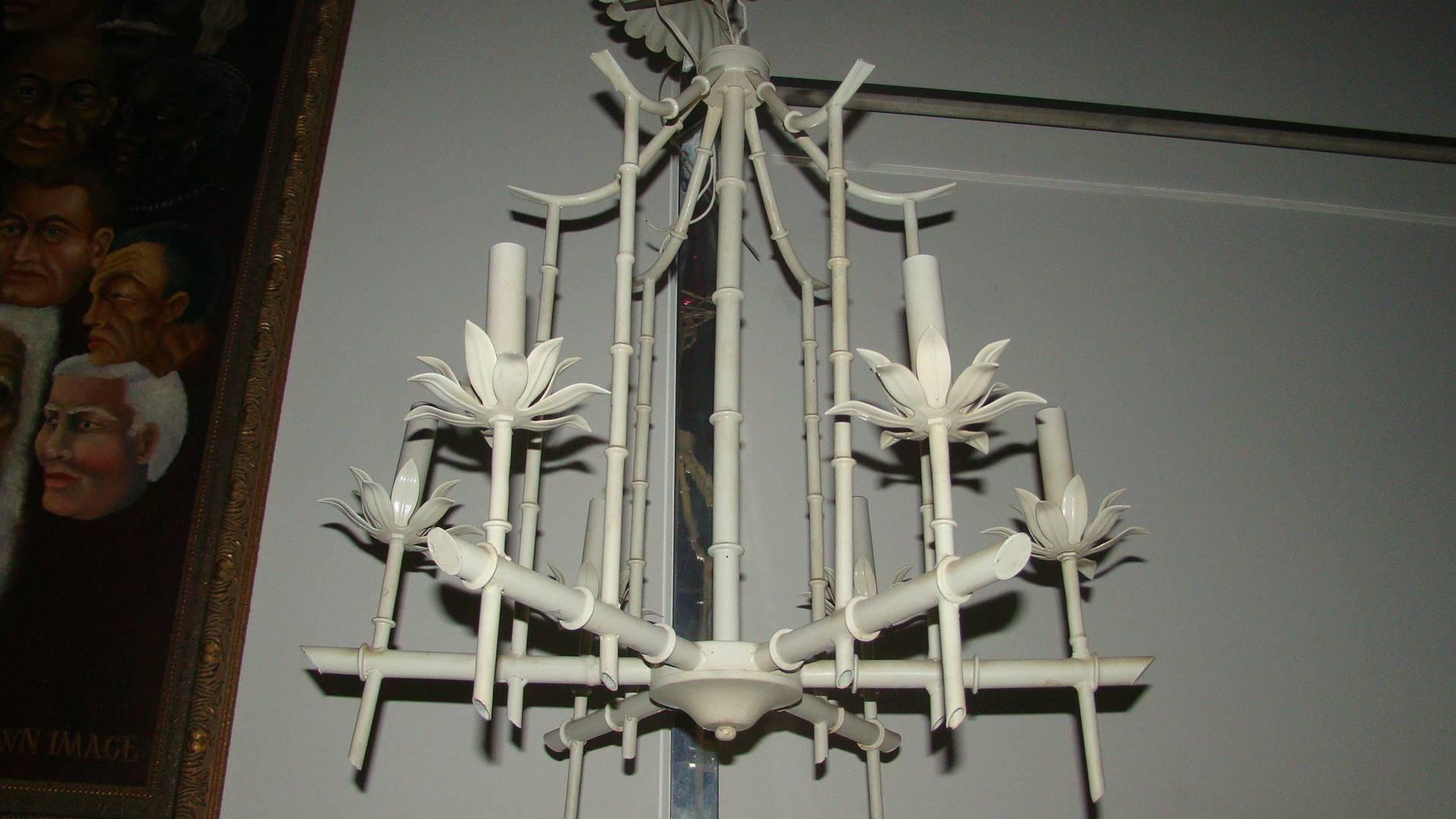 Exceptional hanging faux bamboo Italian chandelier. This beautiful lamp is comprised of six lights in the faux bamboo chinoiserie metal design. The paint is the original off-white color. Retains ceiling cap and chain which adds 18