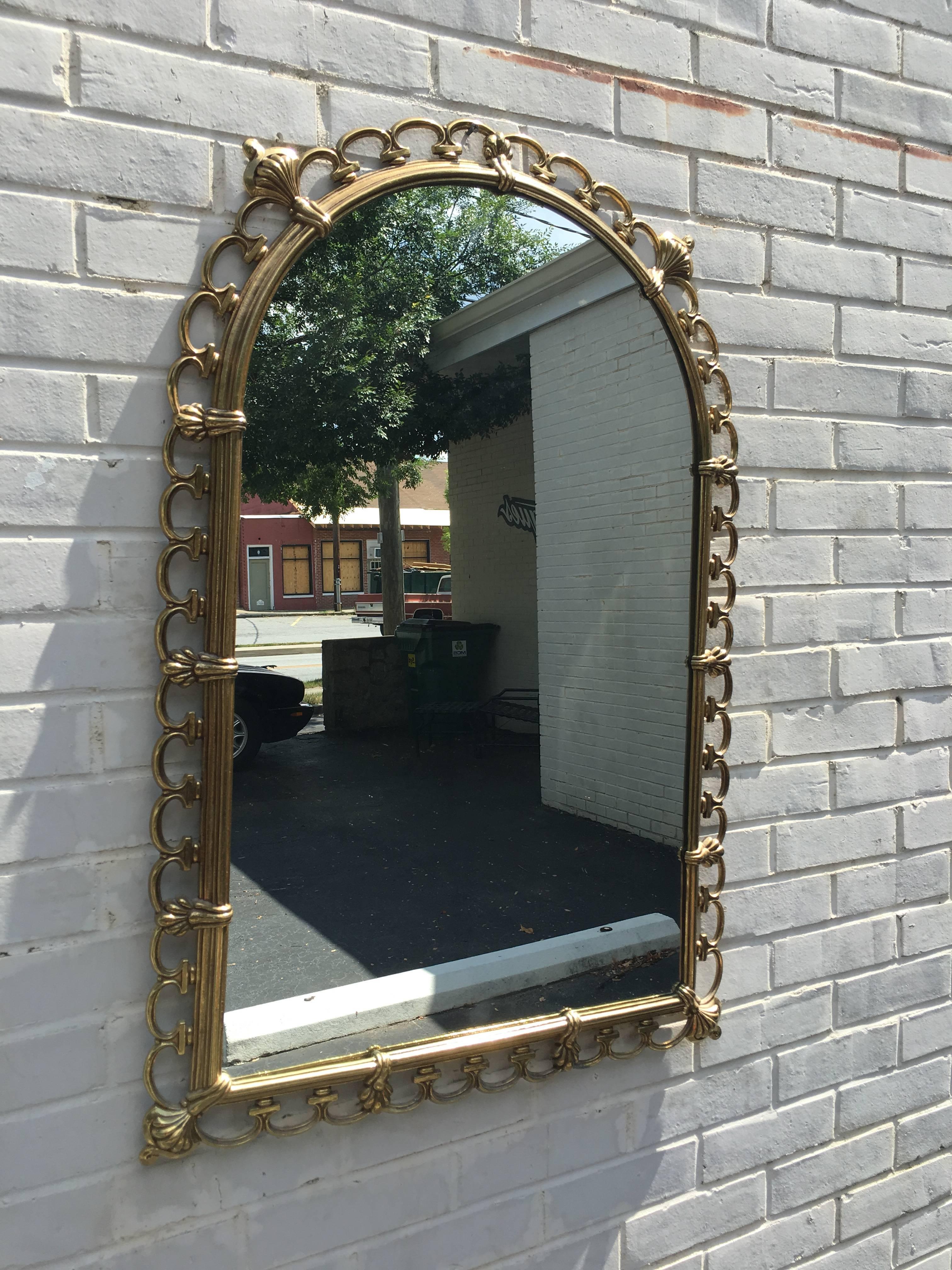 Terrific Italian solid brass wall hanging Chiavari mirror. This design is comprised of a solid polished brass sculptural frame which holds a mirror. Truly a special piece in person.