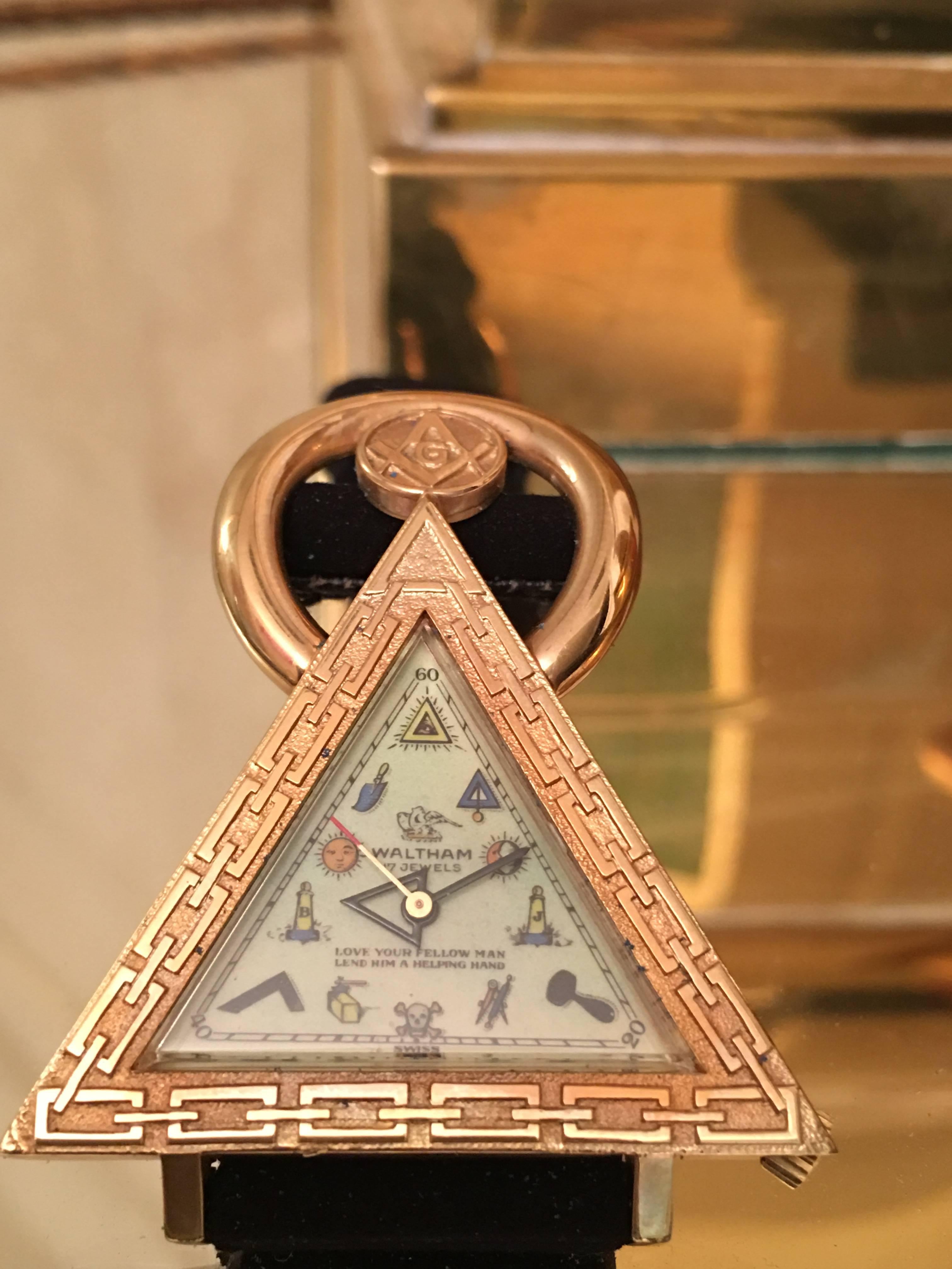 Amazing and hard to find vintage Waltham Swiss Masonic Watch. This interesting sculptural design is comprised of a gold tone triangluar body with Masonic graphics on the face and original suede band. It is a 17 jewel Swiss movement which works