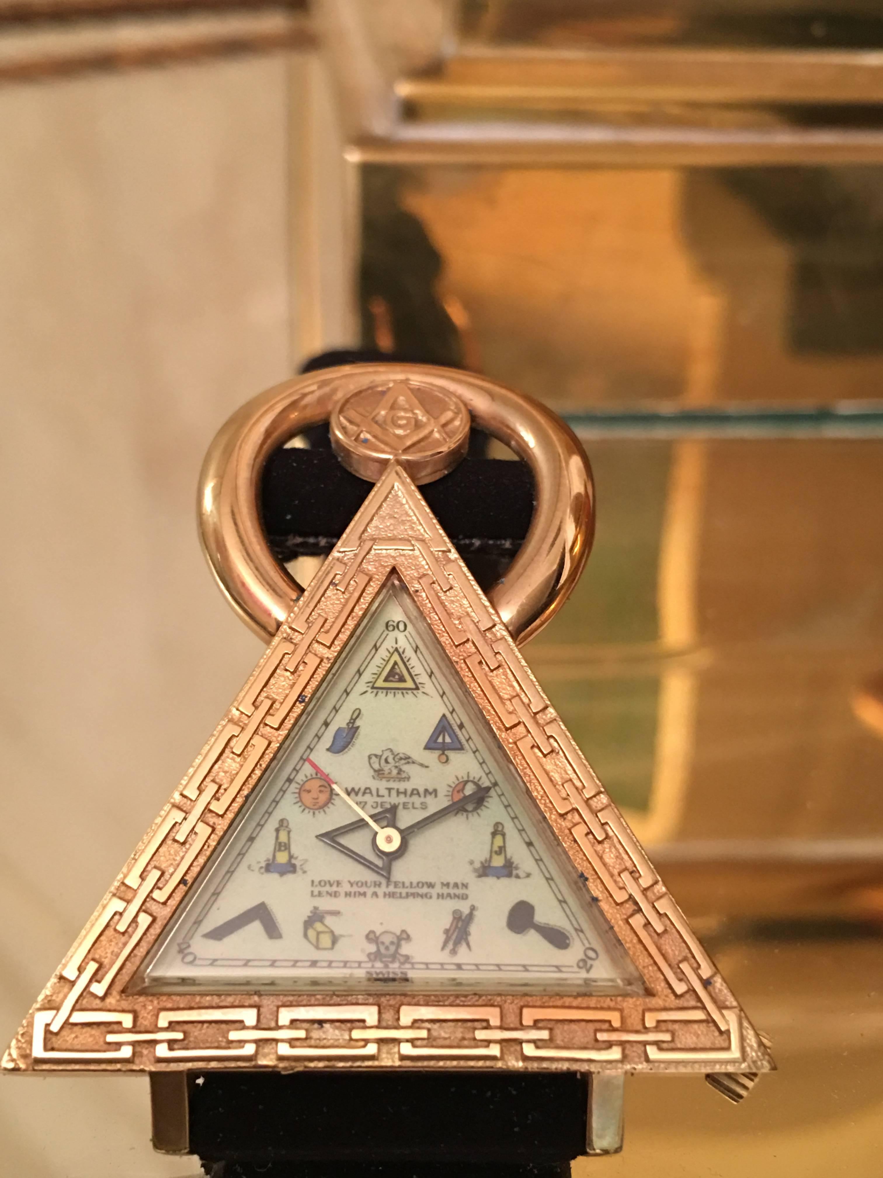 Erstaunlich und schwer zu finden Vintage Waltham Schweizer Freimaurer-Uhr. Dieses interessante skulpturale Design besteht aus einem goldfarbenen Dreieckskörper mit freimaurerischen Grafiken auf dem Gesicht und einem originalen Wildlederband. Es ist