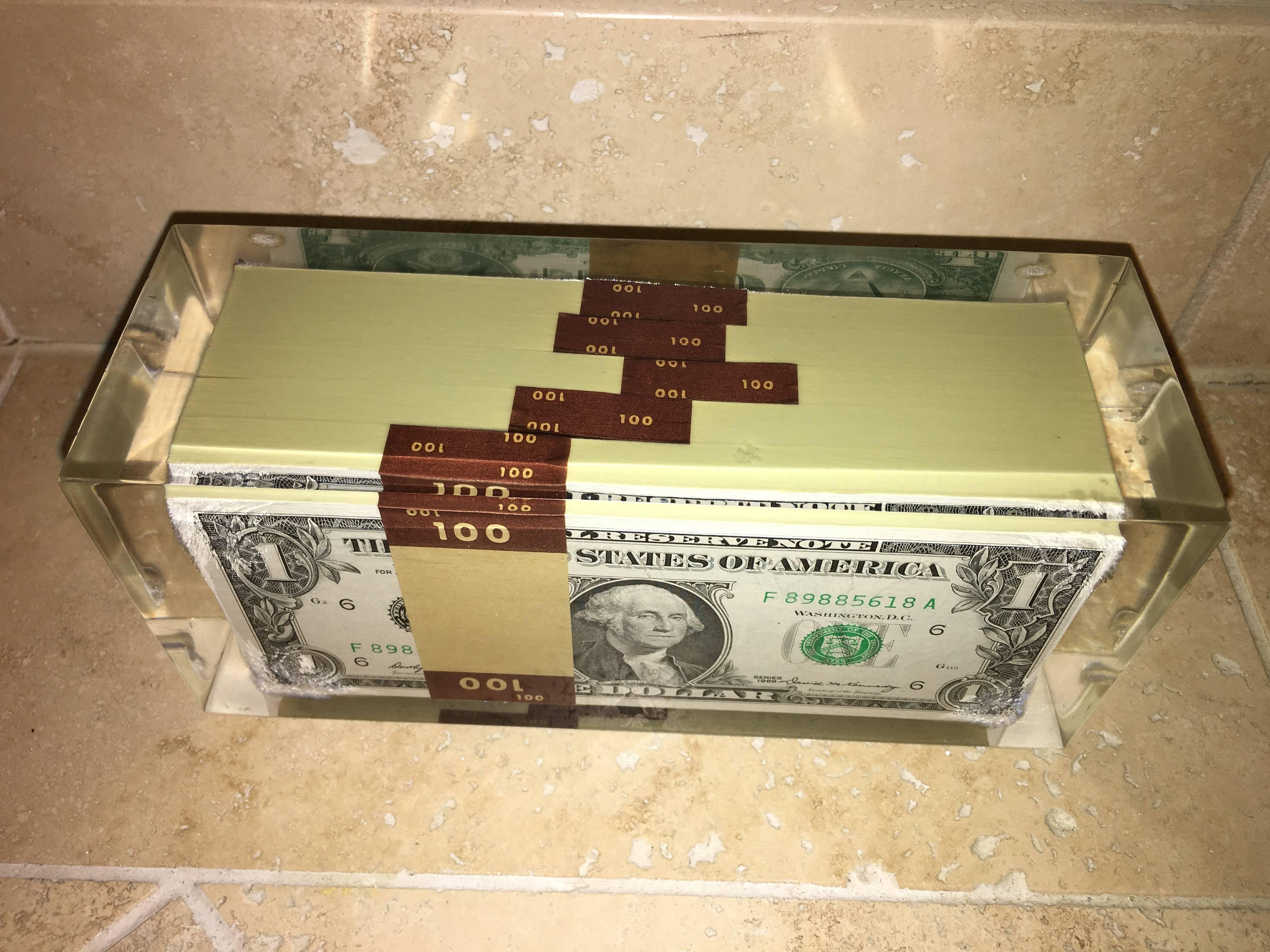 Terrific Lucite encased stack of uncirculated one dollar bills sculpture. This unique object is comprised of five stacks of real 1969 uncirculated $1 bills encased in Lucite. Truly a conversation piece for any collection.