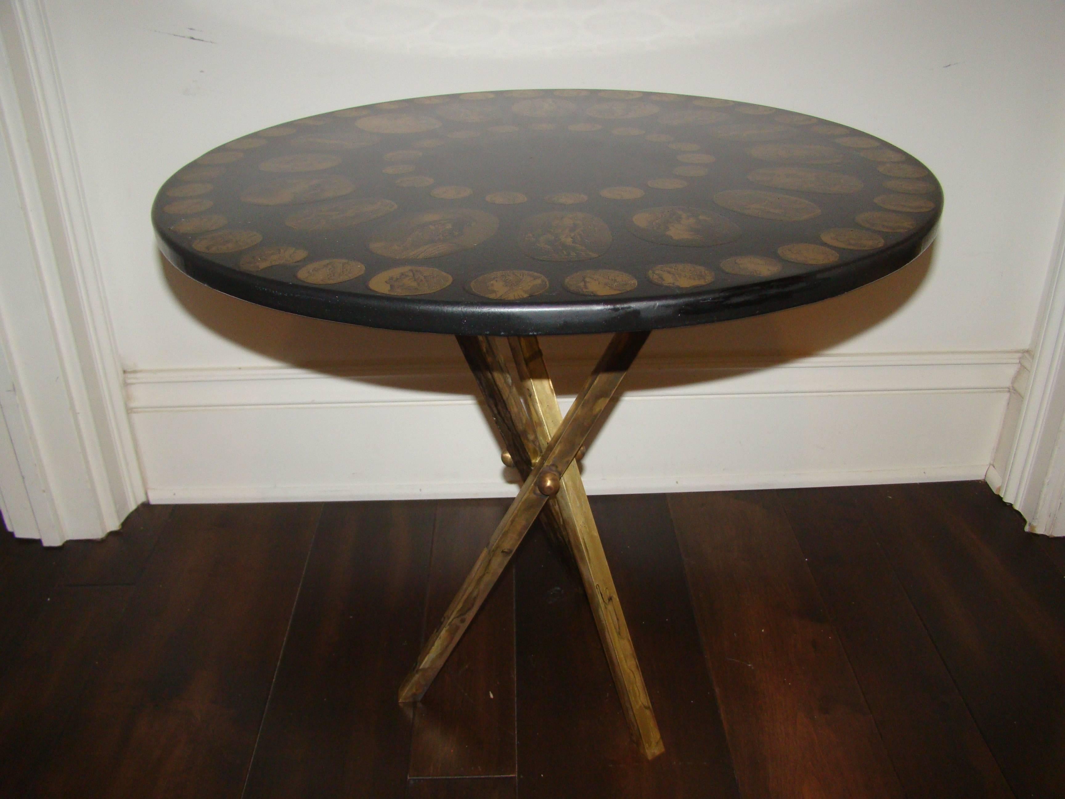 Terrific signed Fornasetti sculptural tripod table. This great table features a brass tripod base with coin motif top. The brass shows signs of patina which may polish up. Truly a great table in person.
