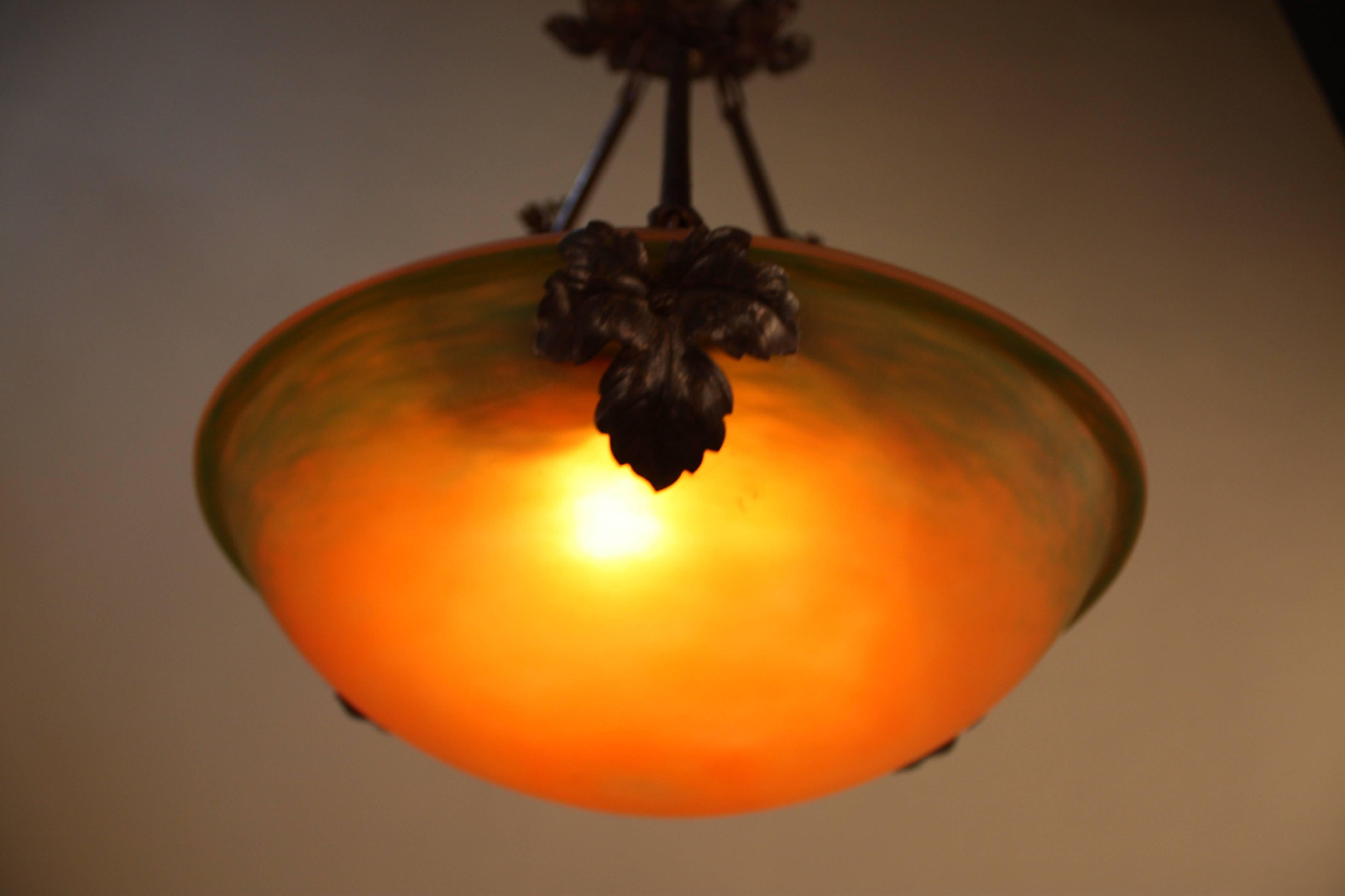 French blown glass from soft green to fiery red an orange suspended with wrought iron hardware chandelier.