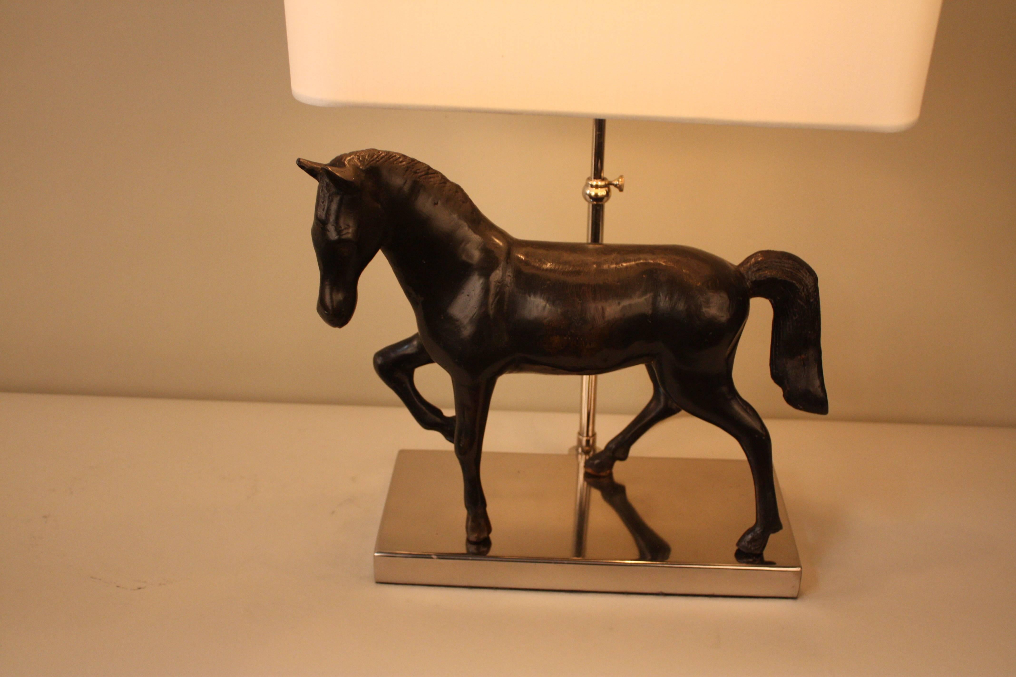 Bronze horse standing on a nickel base table lamp with oblong silk lampshade.