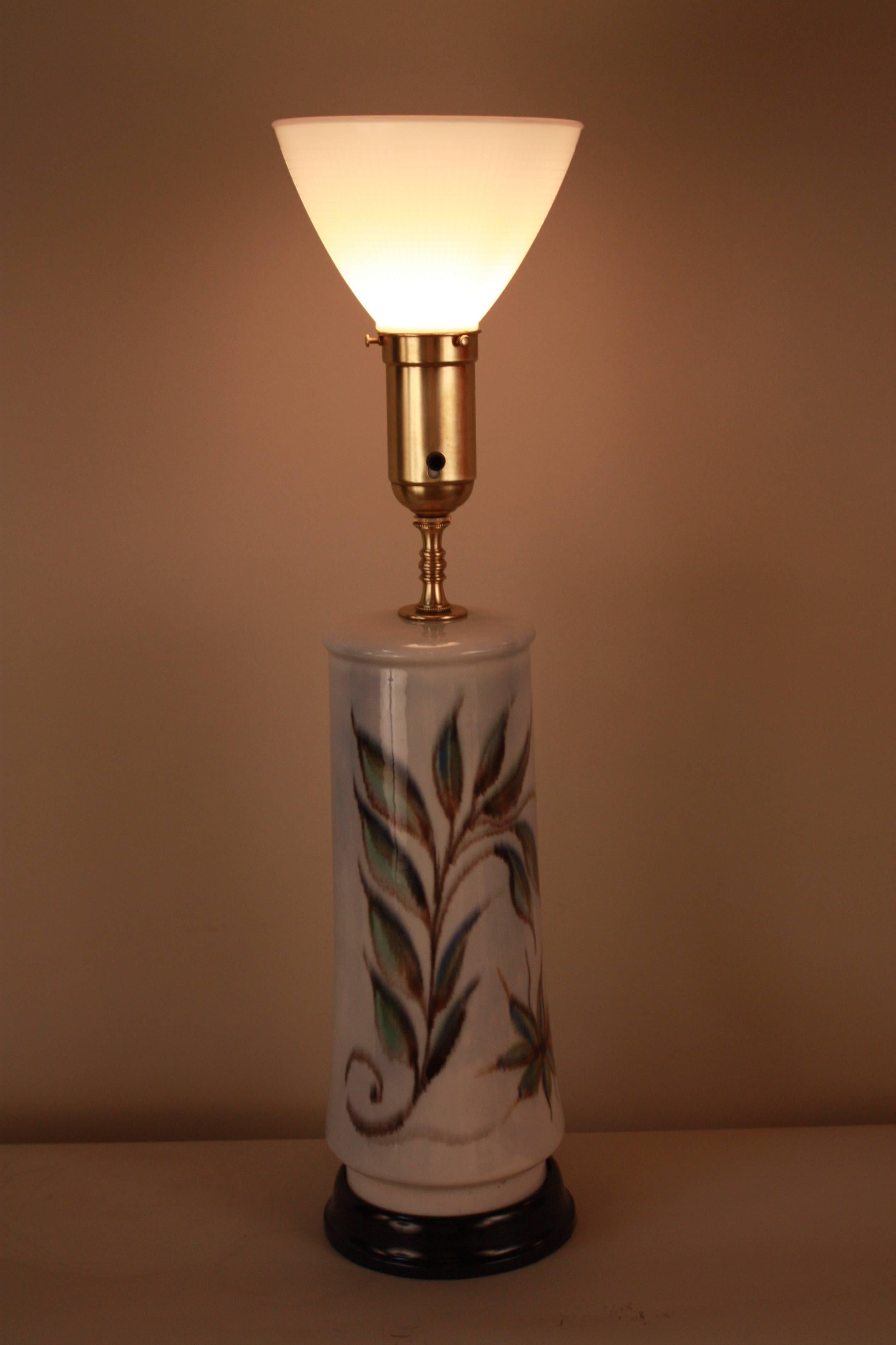 Elegant 1950s painted pottery table lamp with wooden lacquer base.
Fitted with silk lampshade.
 