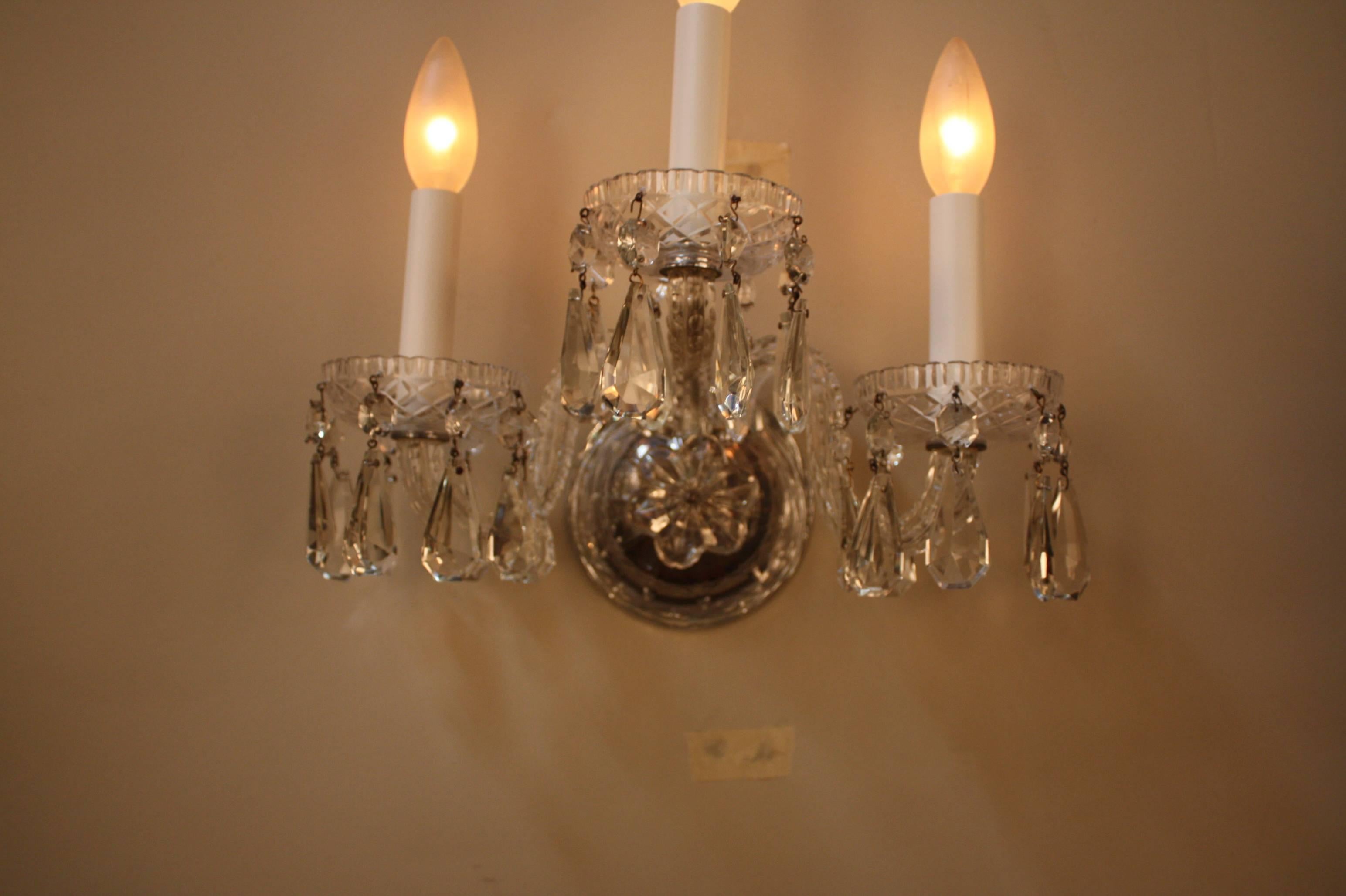 Elegant pair of three-light 1920s German cut crystal wall sconces.