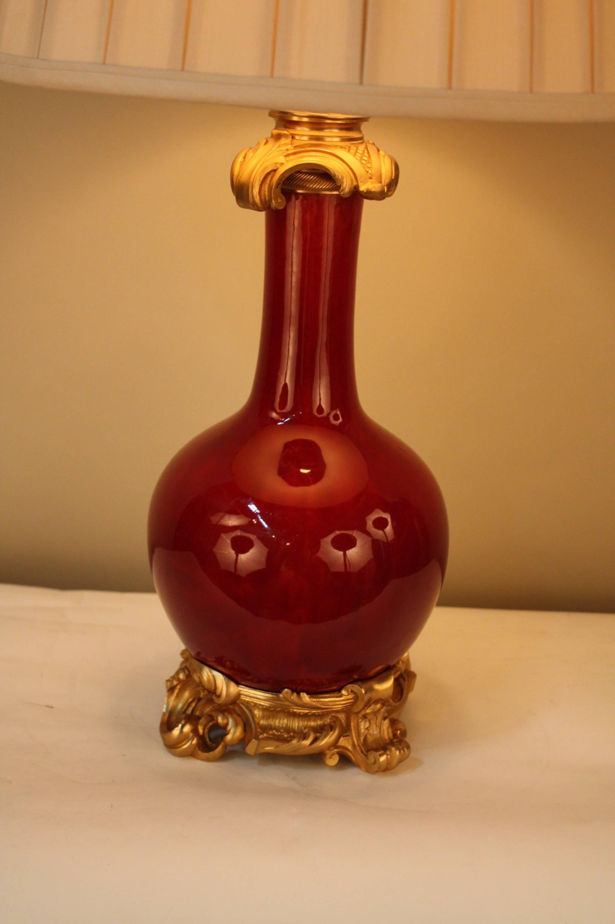 Fine 19th century oxblood sang de boeuf porcelain electrified oil lamp with great doreÌ bronze mounting.