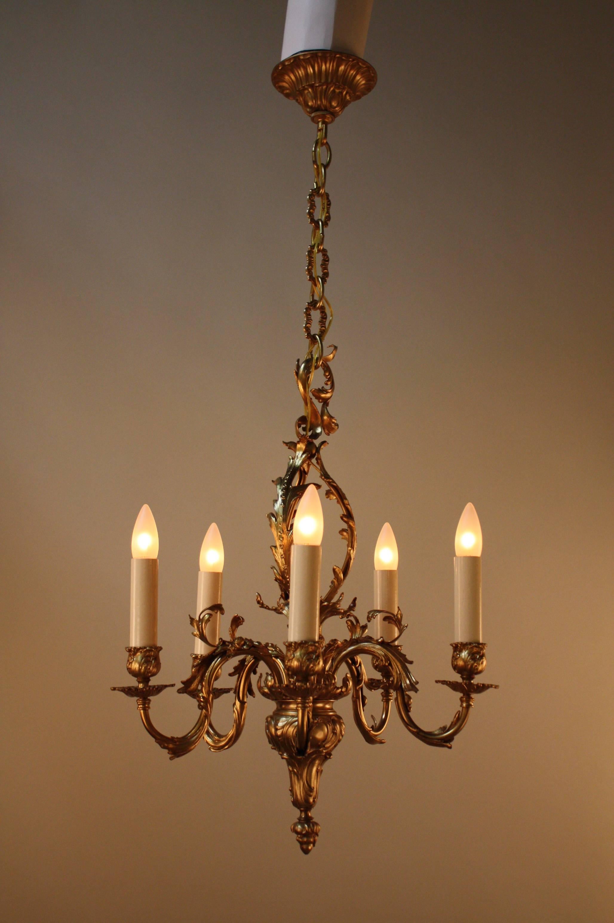 Made in France during the early 20th century, this five-light chandelier features beautiful bronze work. Elegant, intricately crafted details adorn this chandelier from top to bottom.