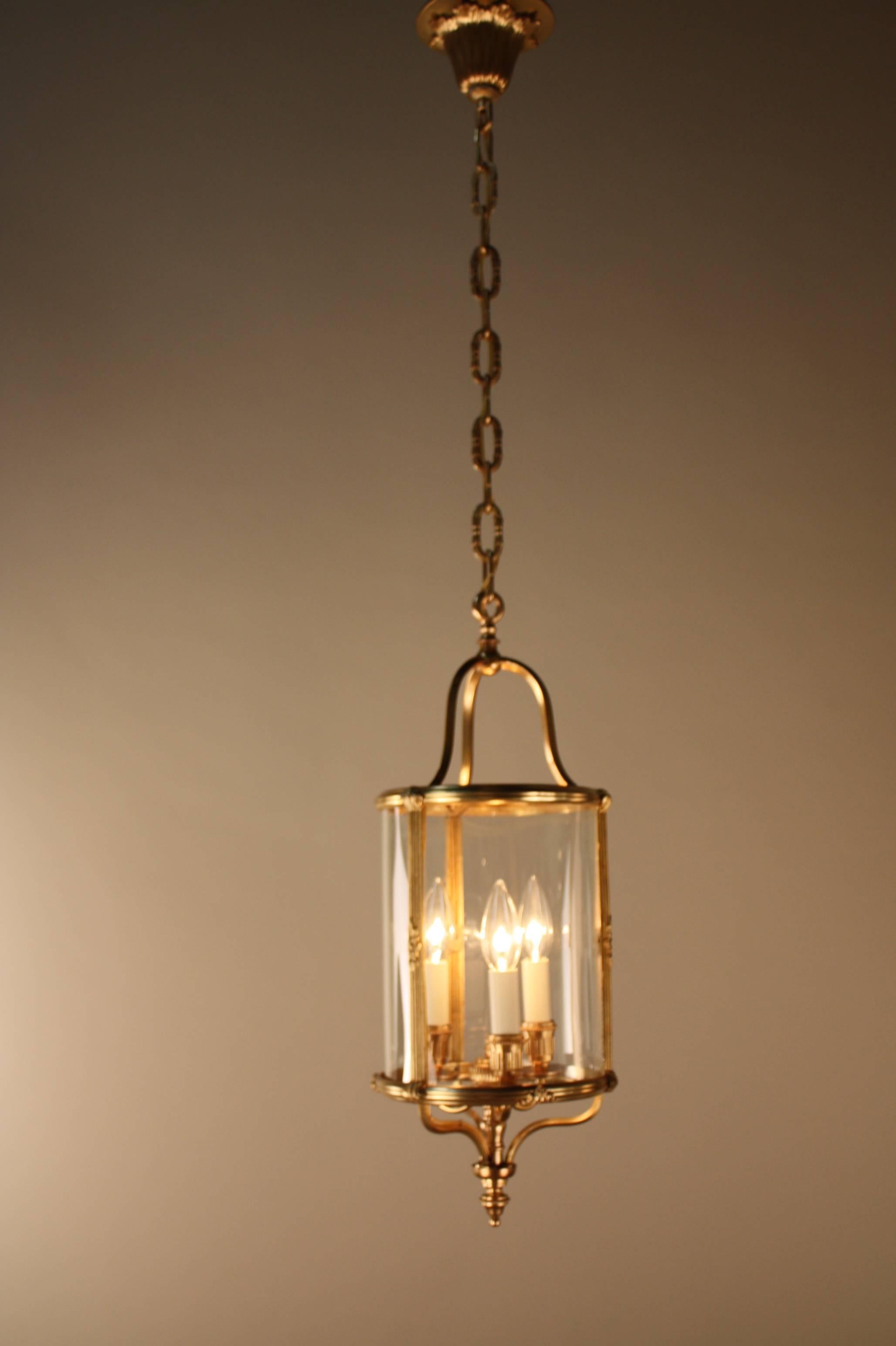 Elegant pair of three-light French bronze with bent glass lanterns by Atelier Petitot.
