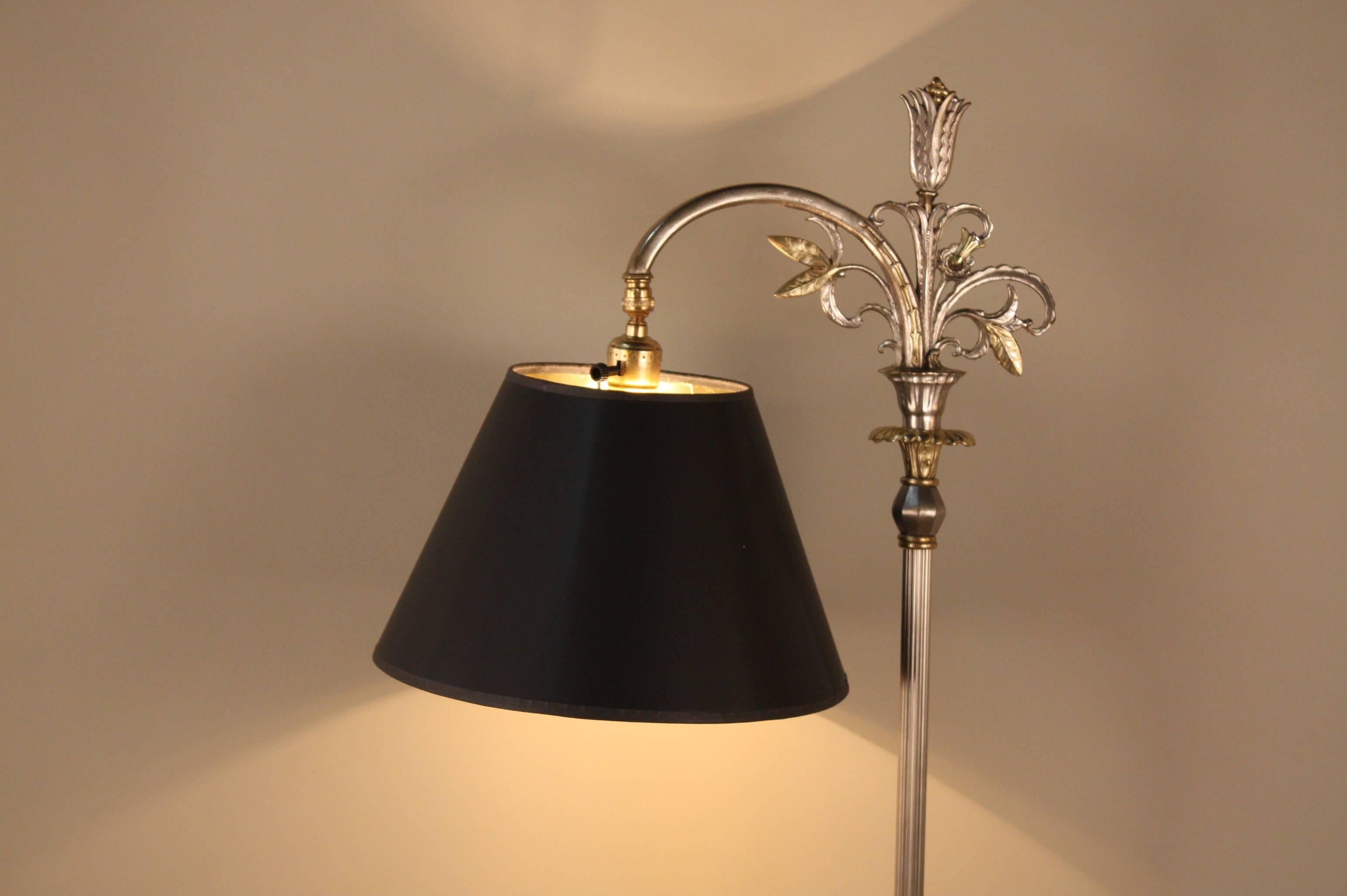 An exquisite American Art Deco floor lamp wit silver and brass finish.
Unusual shape base with two men in brass kneeling where it look like water fountain and the bridge arm is decorated with leaves in brass and silver.