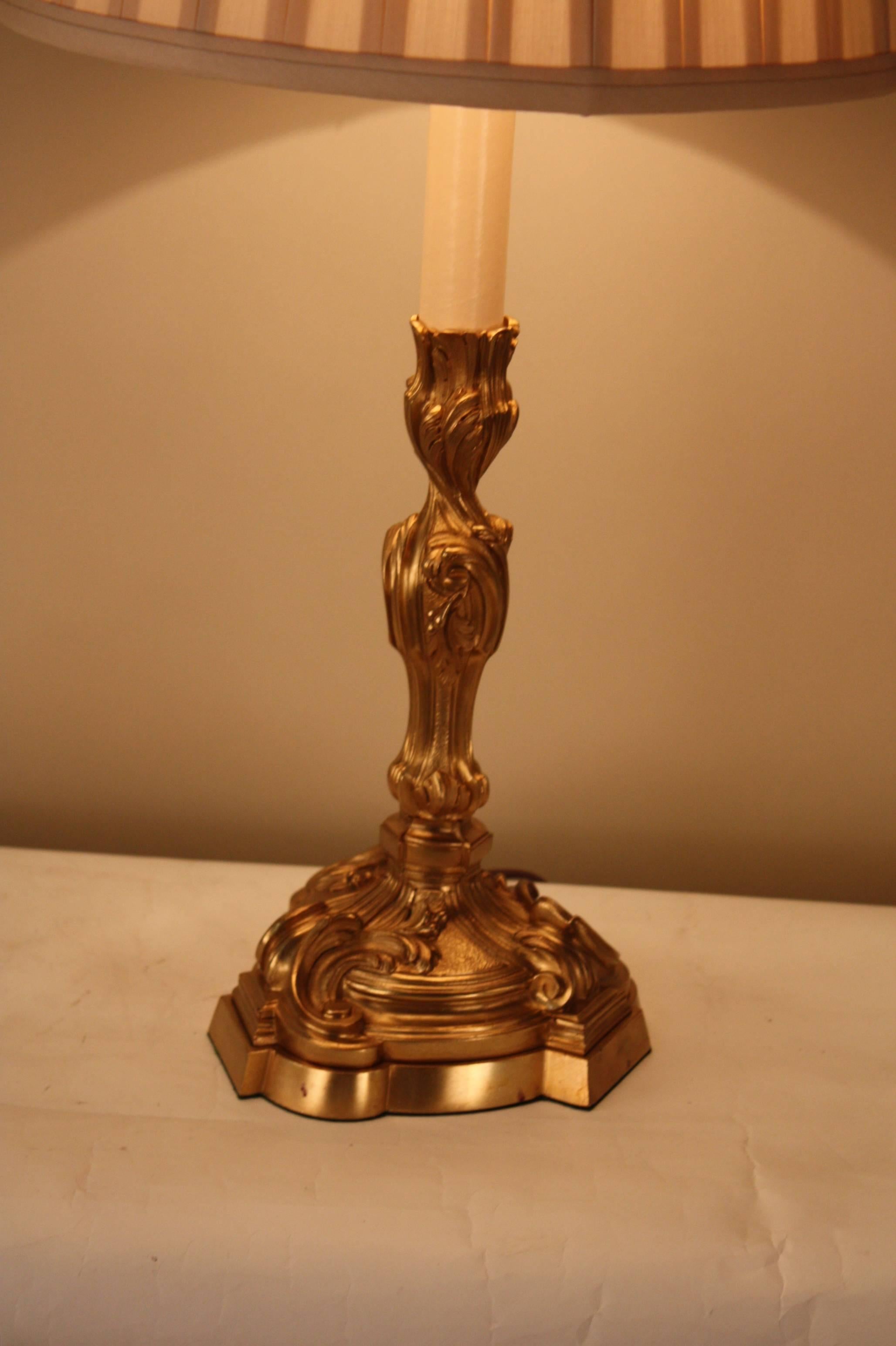 A fabulous Art Nouveau table lamp customized from a bronze candlestick with great detail work and design and fitted with handmade box pleated silk lampshade.