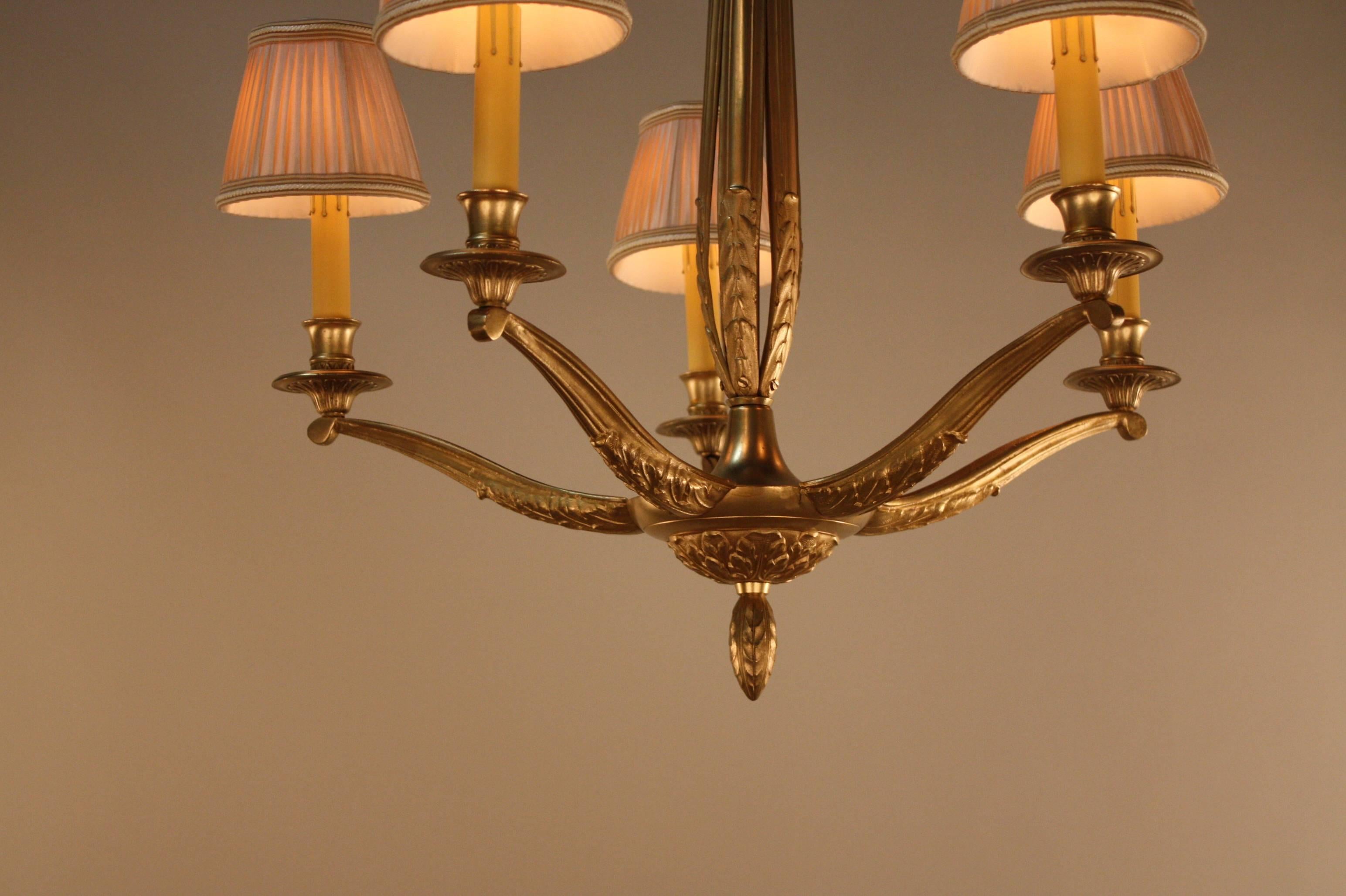 An elegant five-light French bronze chandelier. This golden bronze artisan chandelier represent quality and workmanship of 1930s area.
This chandelier has 28