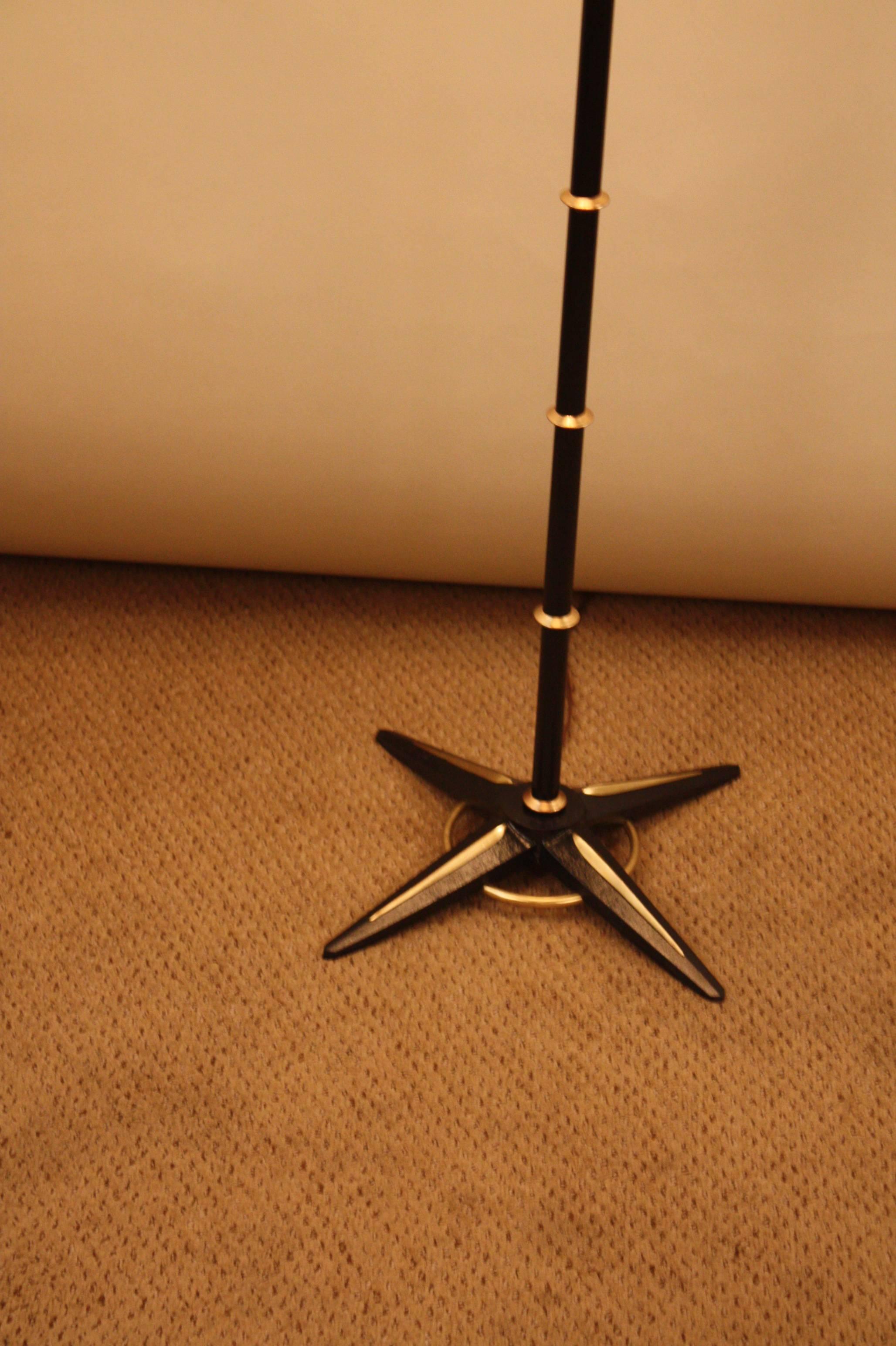 Mid-Century star adjustable four-light floor lamp by Jacques Adnet. The black lacquer column this elegant floor has been divided by few discs that gives it a distinctive look.