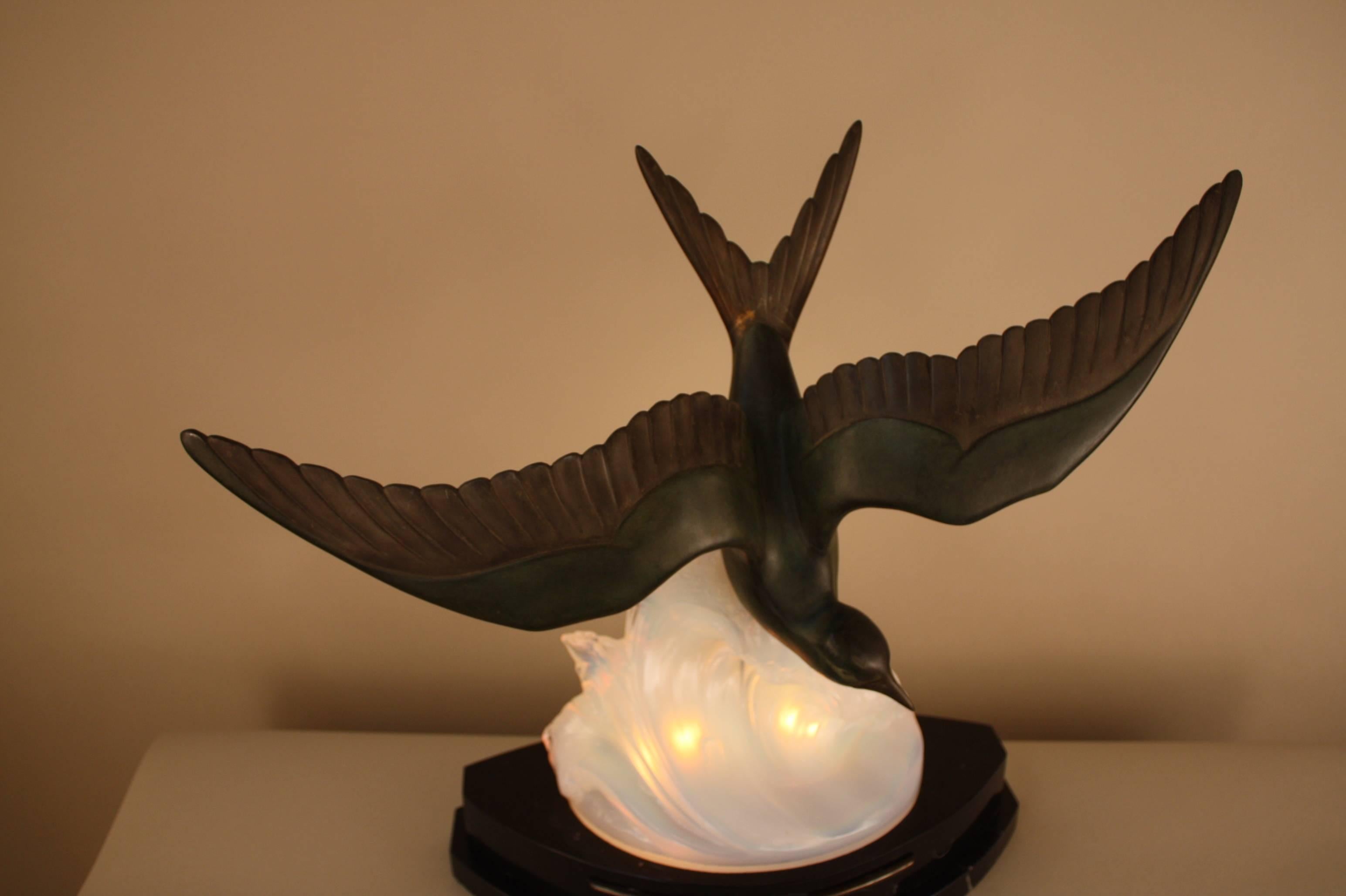 Beautiful Art Deco table lamp. A bird in a flying motion over opalescent, blue / honey color sea wave siting an black onyx.