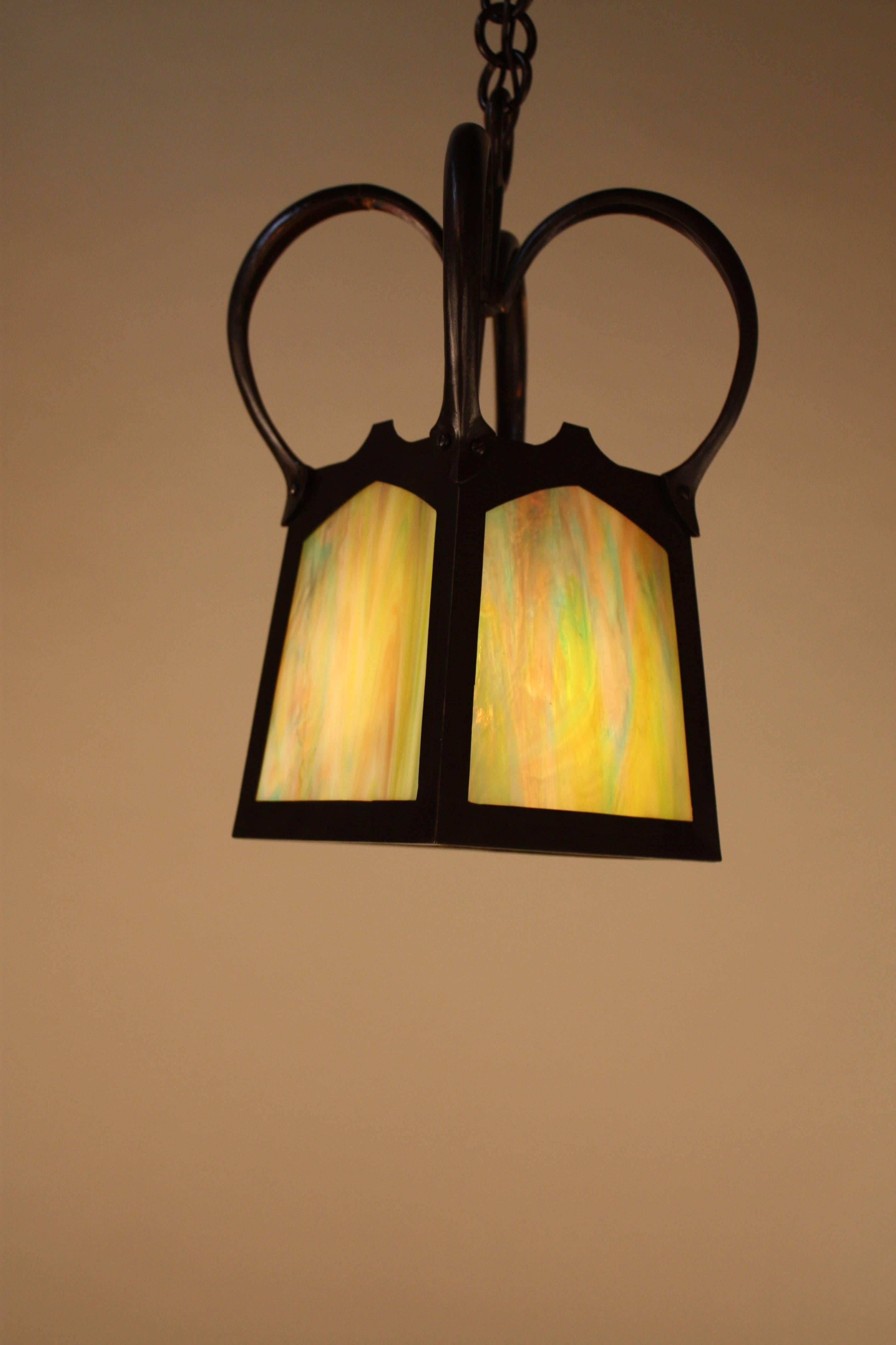 Beautiful single light hanging bronze lantern. This piece features multicolored stained glass in dark bronze frame from Arts & Crafts or Art Nouveau period.