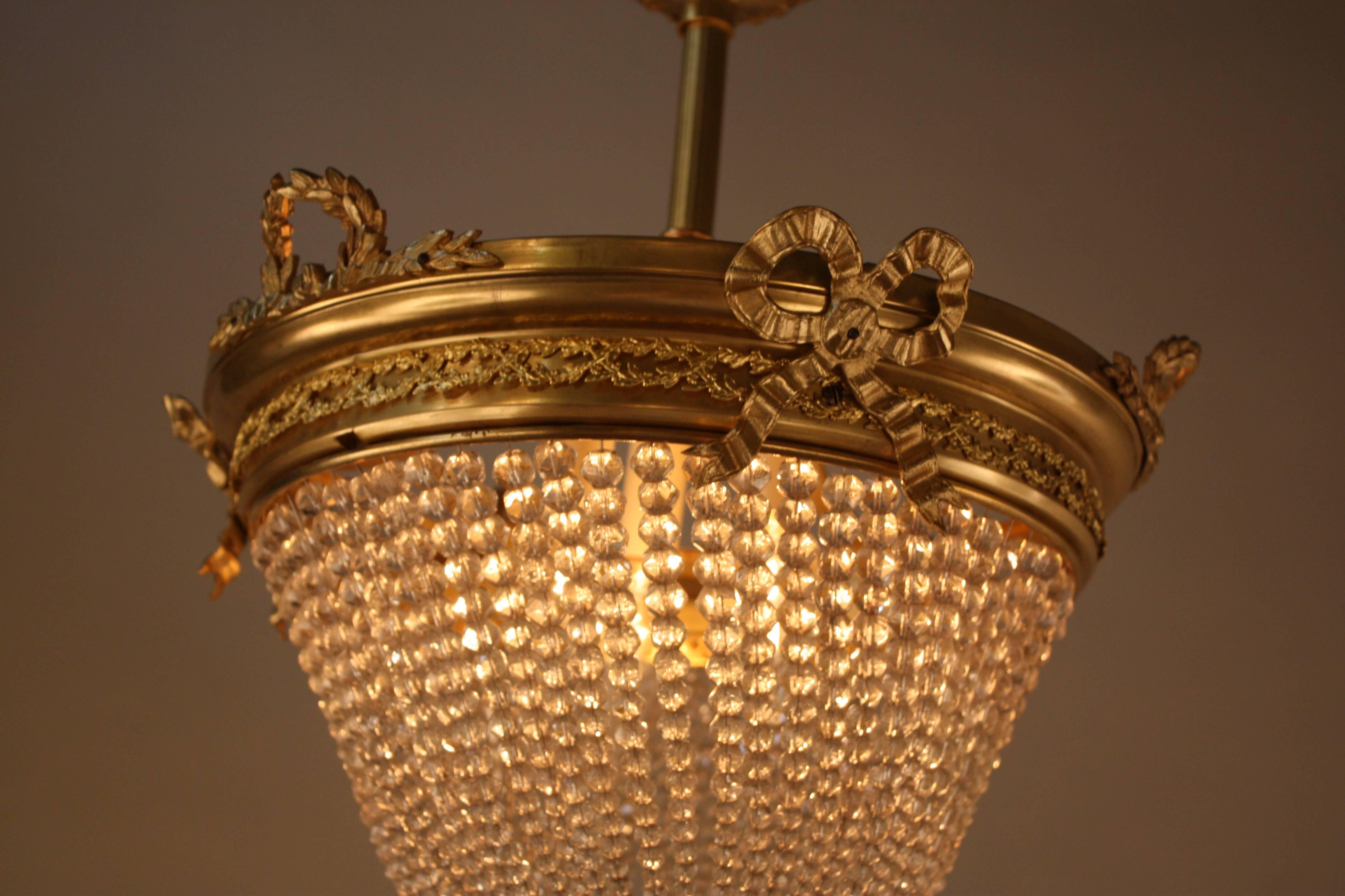 A fabulous1920s three light beaded crystal basket chandelier with fantastic bronze frame and hardware.