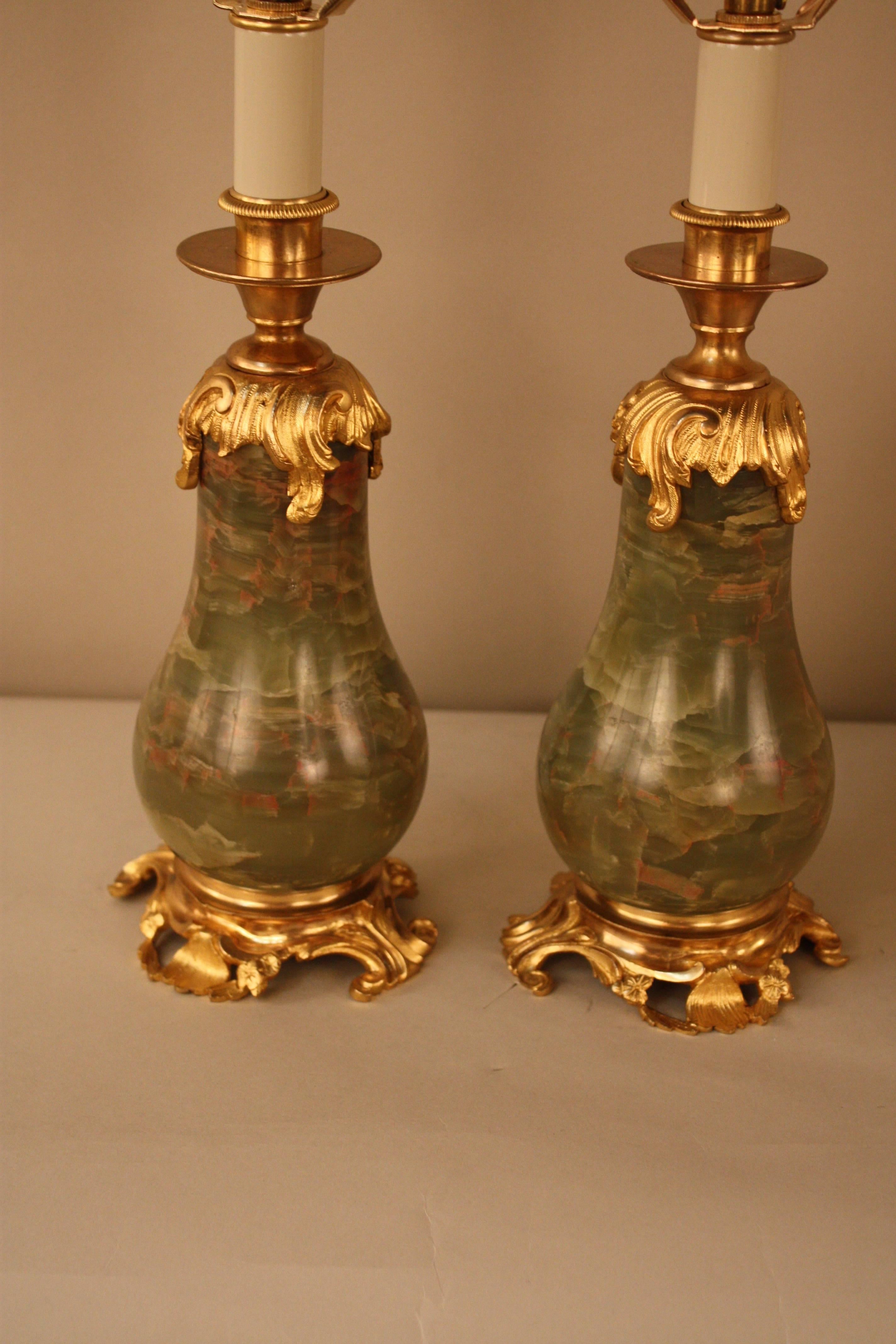 A fabulous pair of neoclassic design green onyx and doré bronze custom-made table lamps.
These beautiful lamps are fitted with hand made silk lampshades.