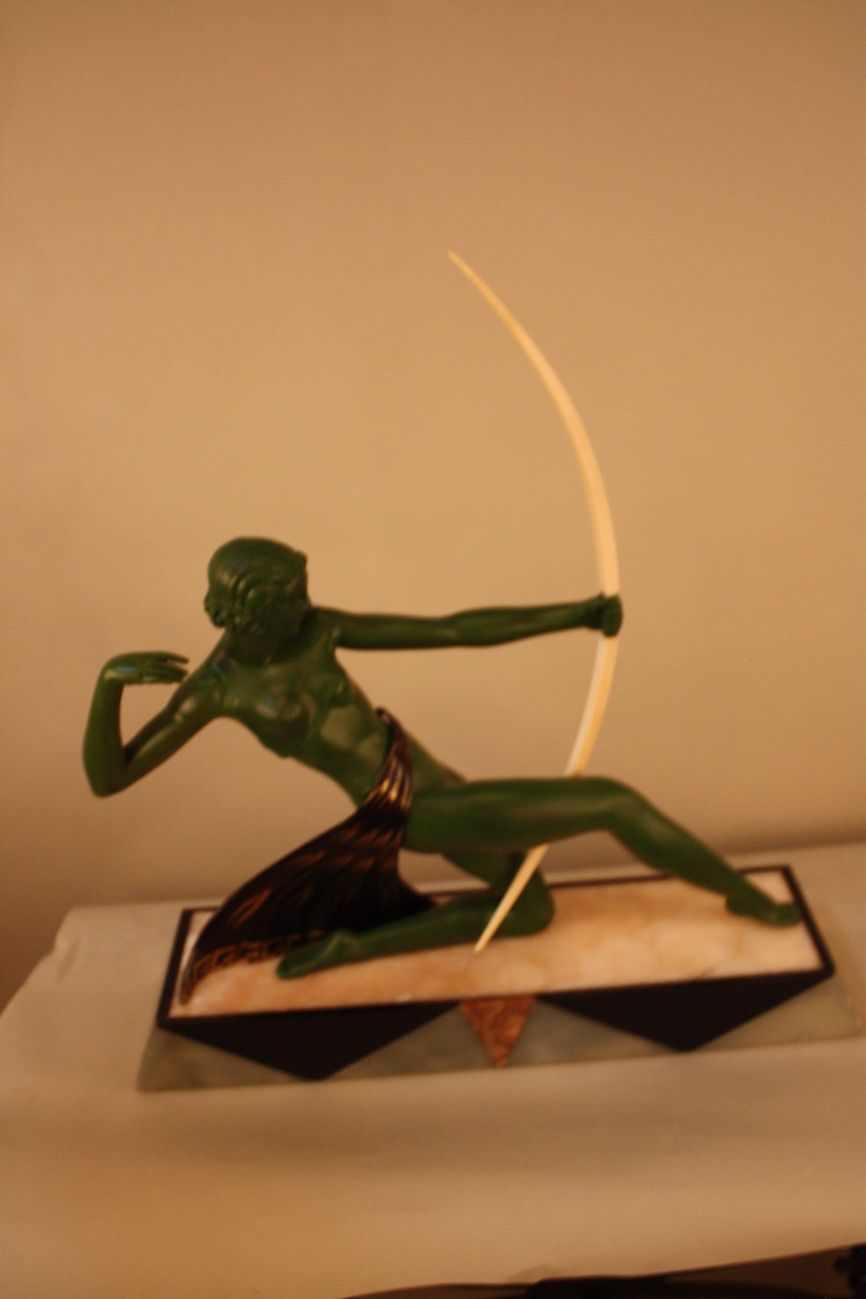 A classic Art Deco sculpture Diana the hunter from 1920s, France. Painted spelter sitting on stylized onyx.