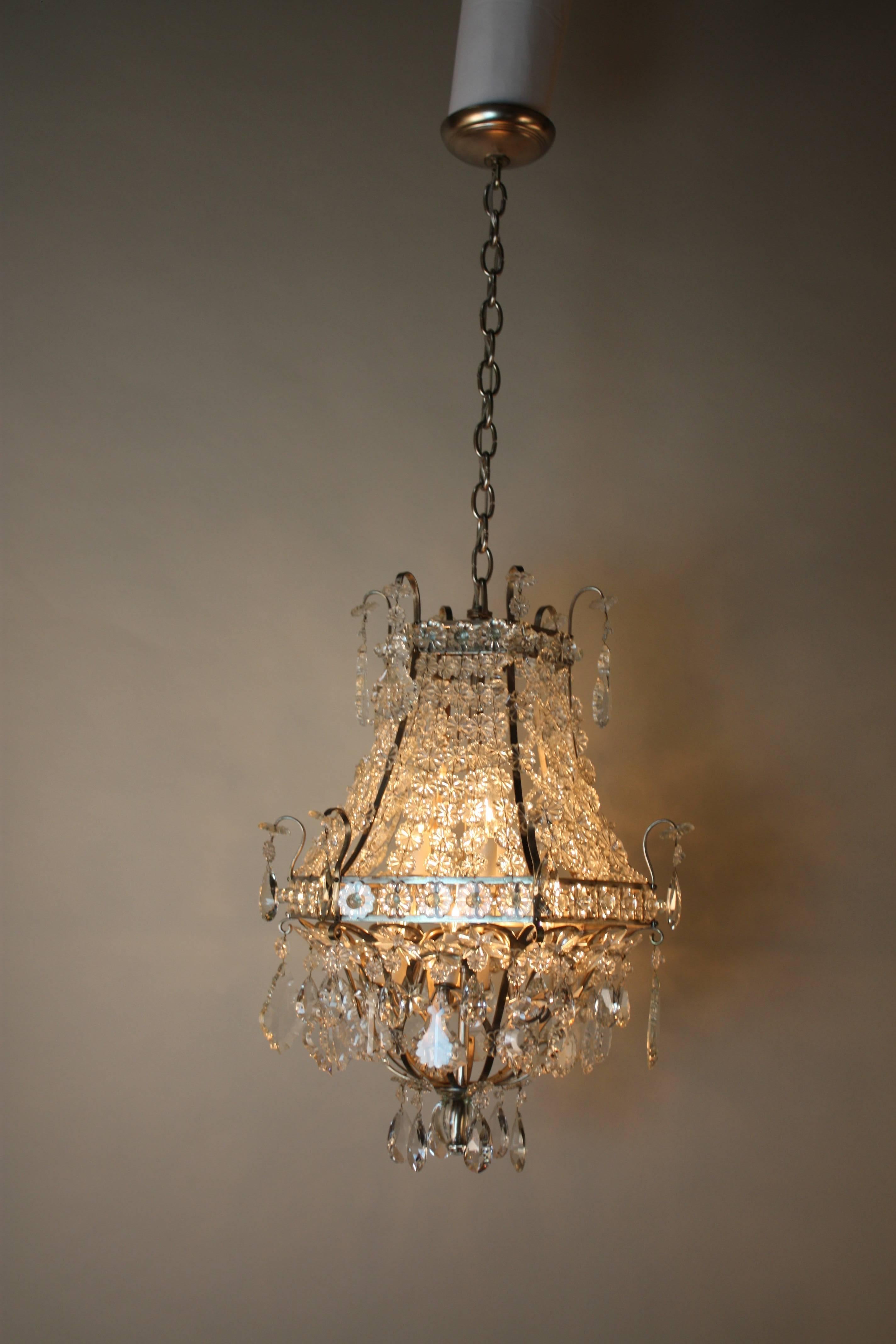 Hundreds of individually placed crystals ornately adorn this gorgeous nine-light chandelier from top to bottom. Handcrafted in Italy during the 1950s, this Mid-Century fixture features a wonderful nickel on bronze design.