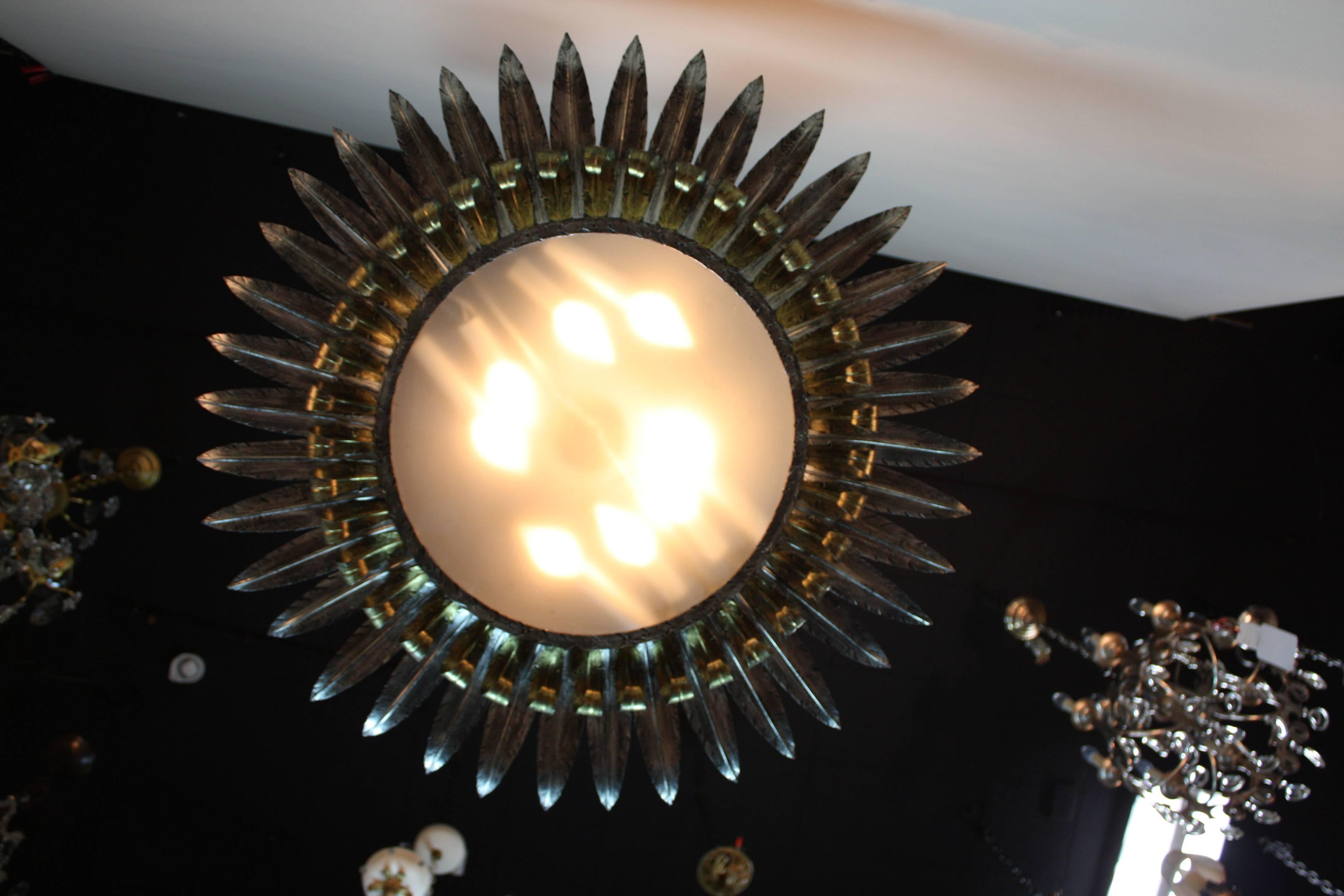 Fantastic semi large flush mount eight-light fixture in combination of silver and gold leaf. Made in Spain during 1950s a Classic art work in shape of sun blast or sunflower.
   