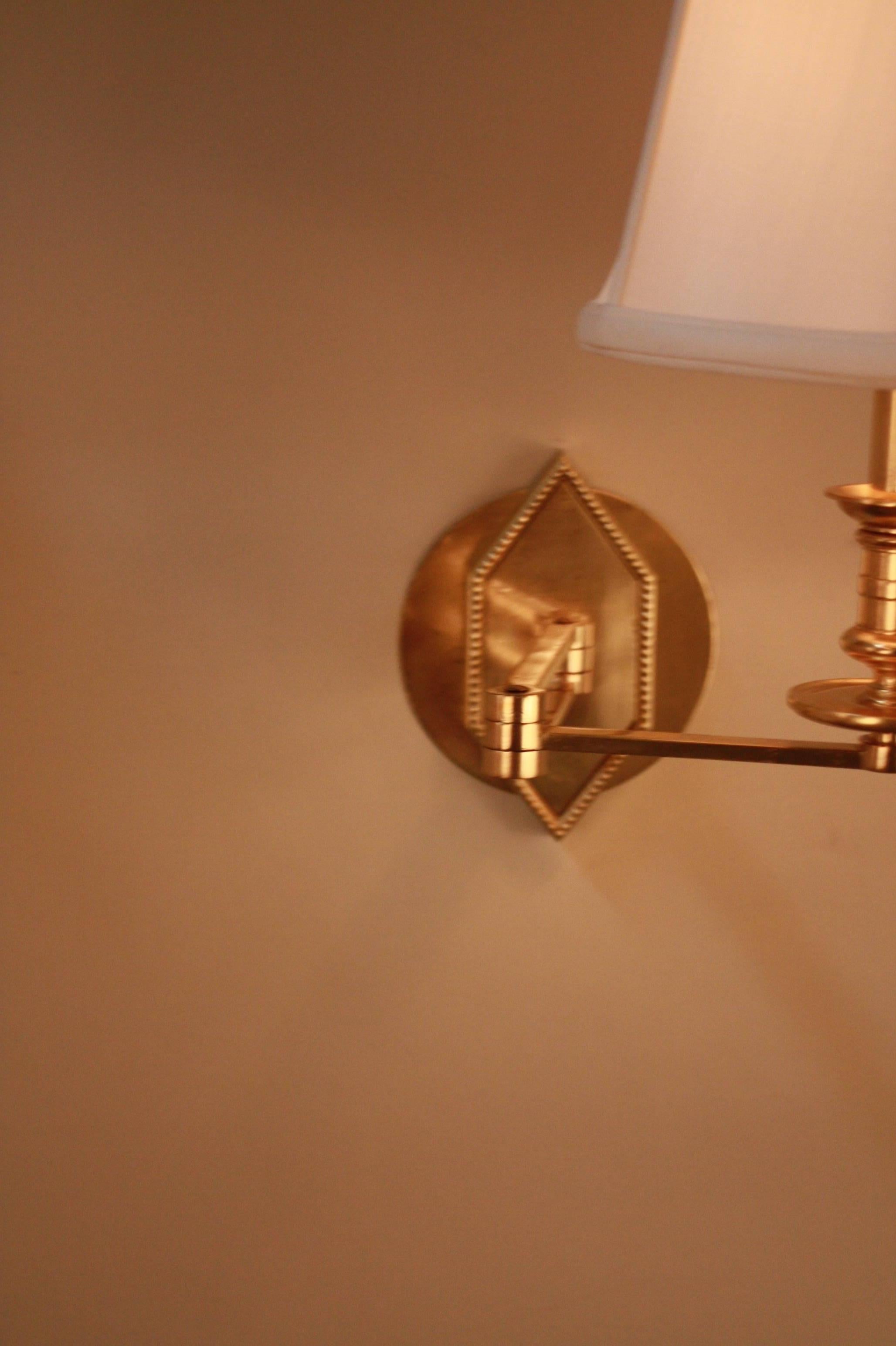 Pair of French1970s bronze swing arm wall sconces fitted with silk lampshades and dimmer switch.