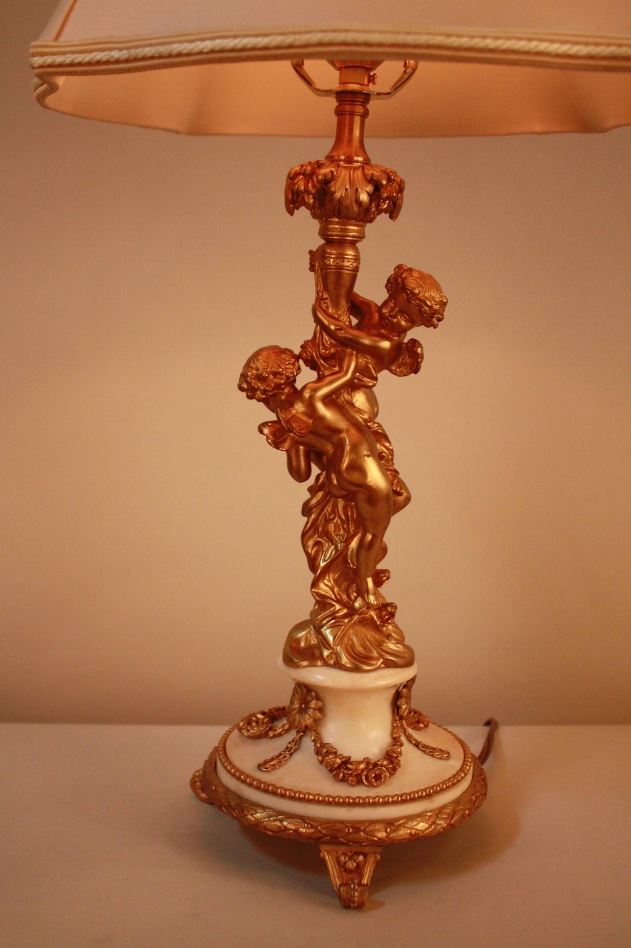 Bronze cherubs climbing the flora tree sitting on a marble base with bronze decoration table lamp.