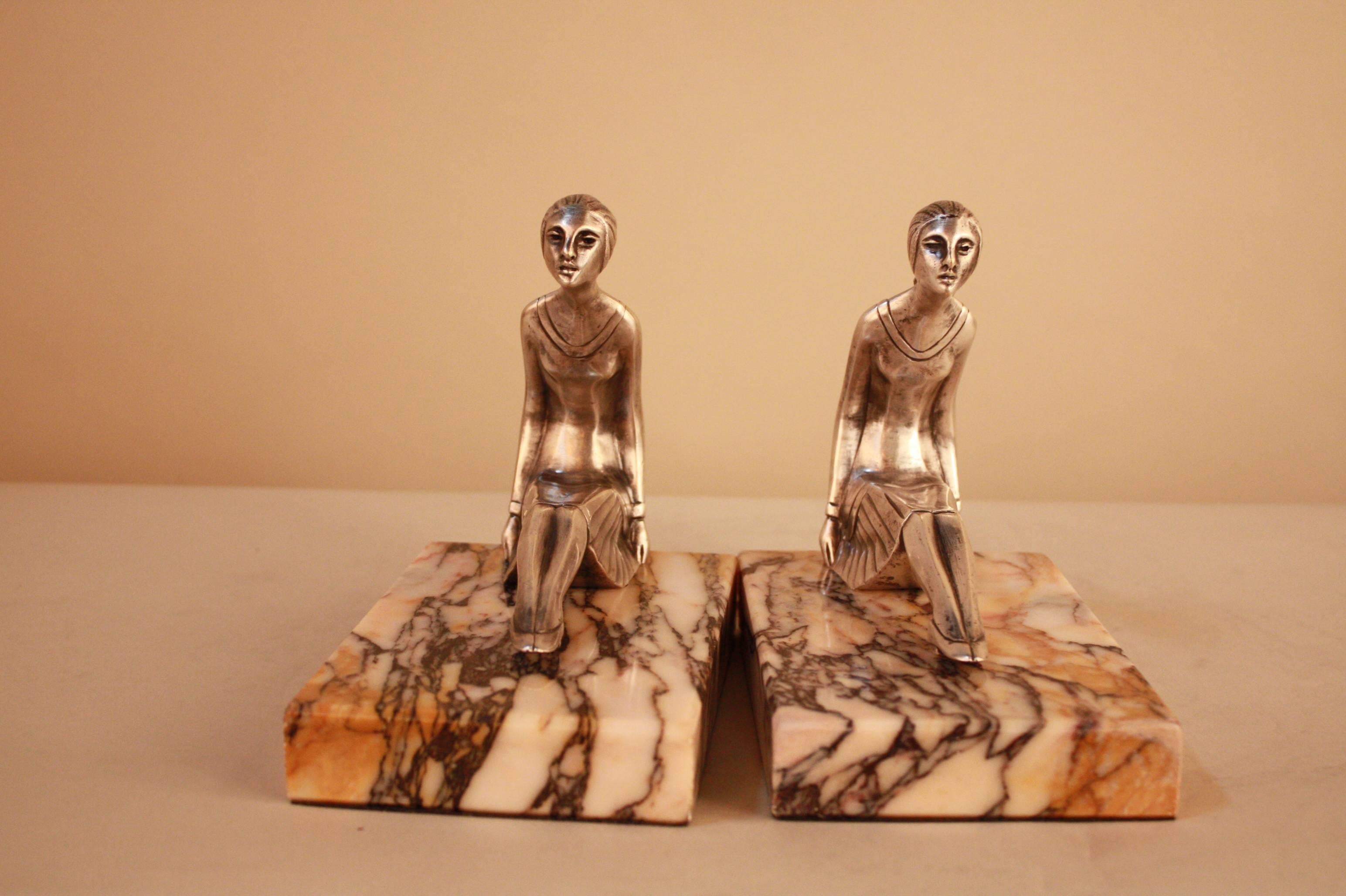A pair silver on bronze with modern design two women back to back, sitting on marble base bookends. Art deco often features the female form, and these two are crafted with incredible detail. Perfect for a study bookshelf. 